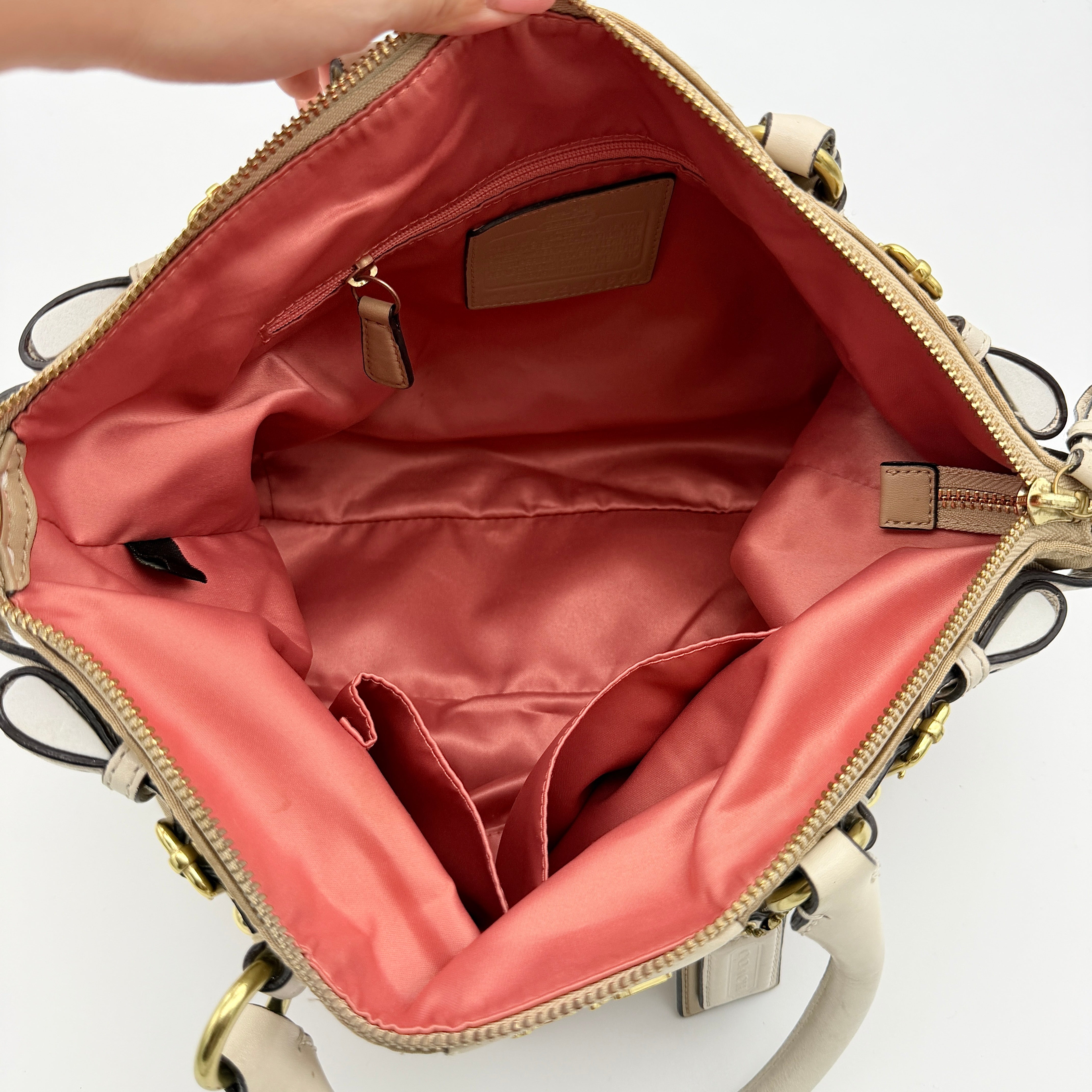 Beige Coach Madison Op Art Sophia shoulder bag with ivory leather handles, gold hardware, and detachable strap.