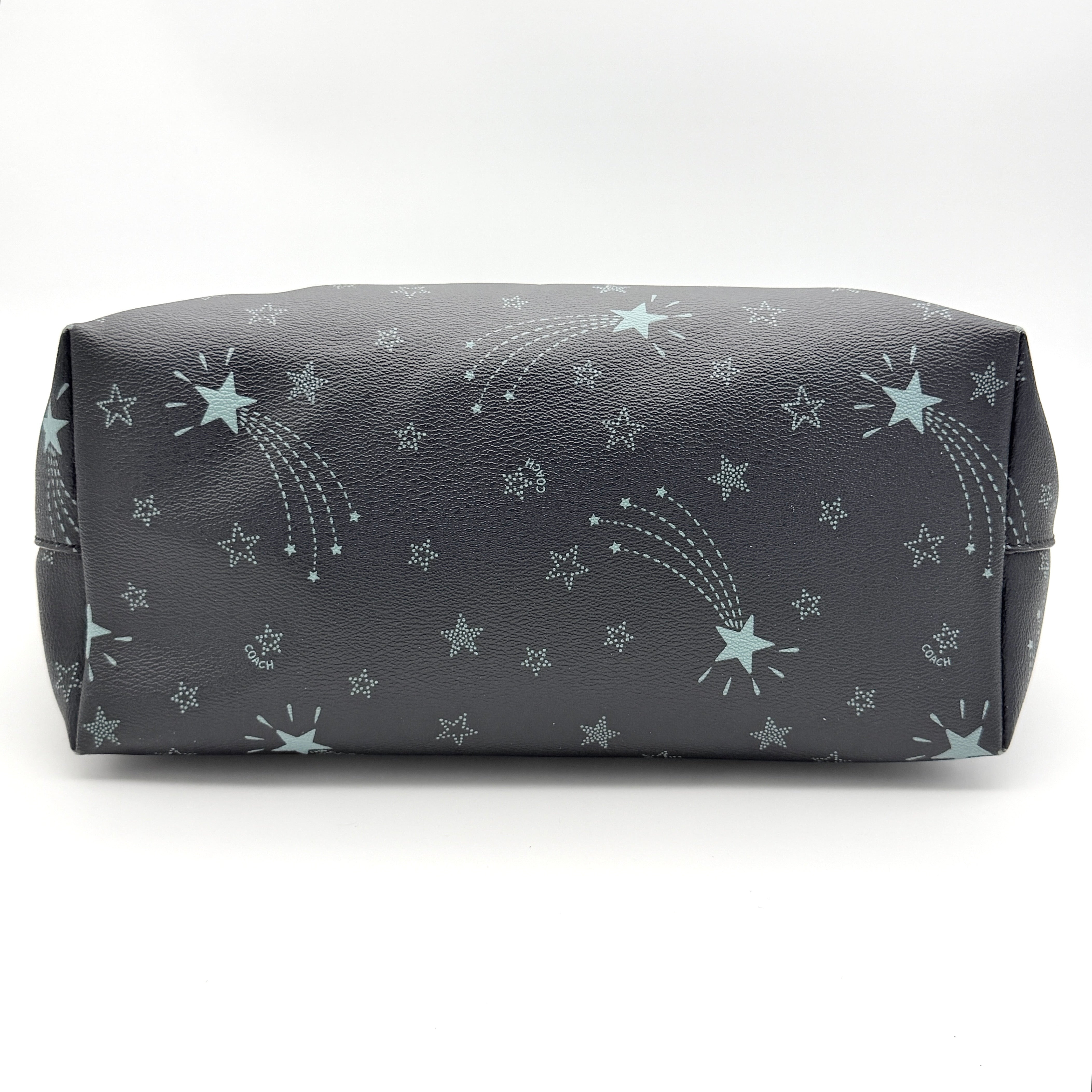 Coach Fiona Zip Tote in navy blue with star print and blue leather handles against a white background.