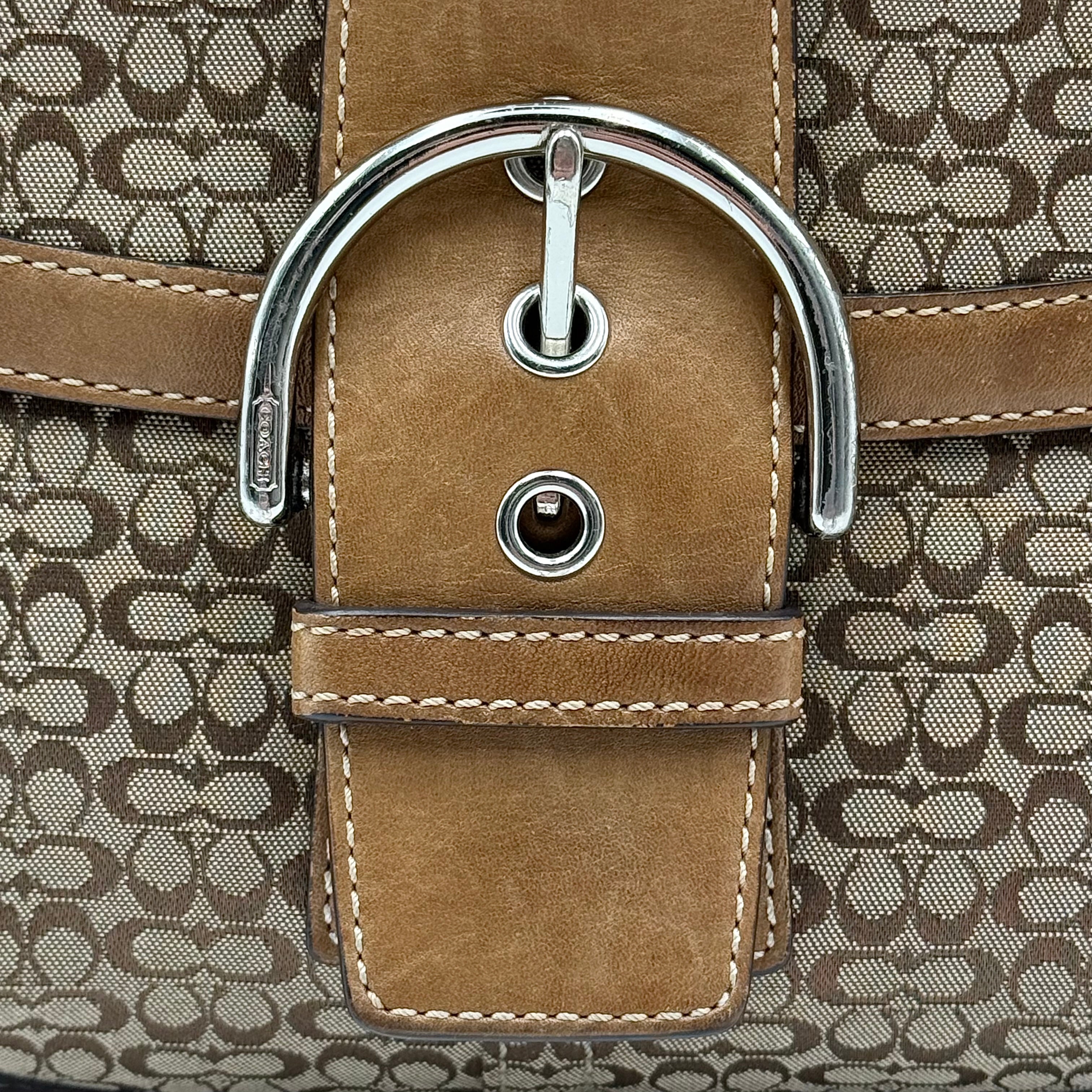 Coach Signature Soho shoulder bag in beige and tan jacquard with leather trim and silver D-ring buckle, shown against a white background.