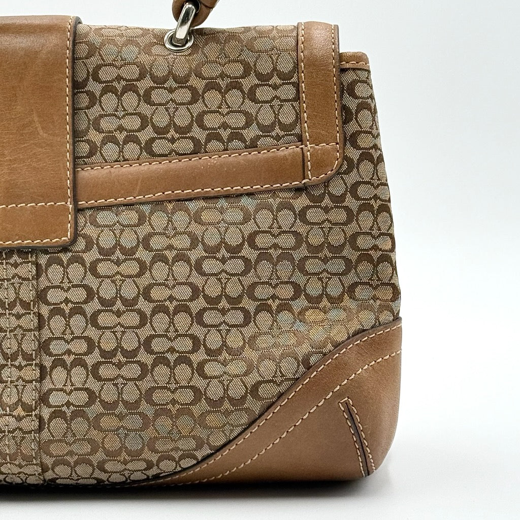 Coach Signature Soho shoulder bag in beige and tan jacquard with leather trim and silver D-ring buckle, shown against a white background.