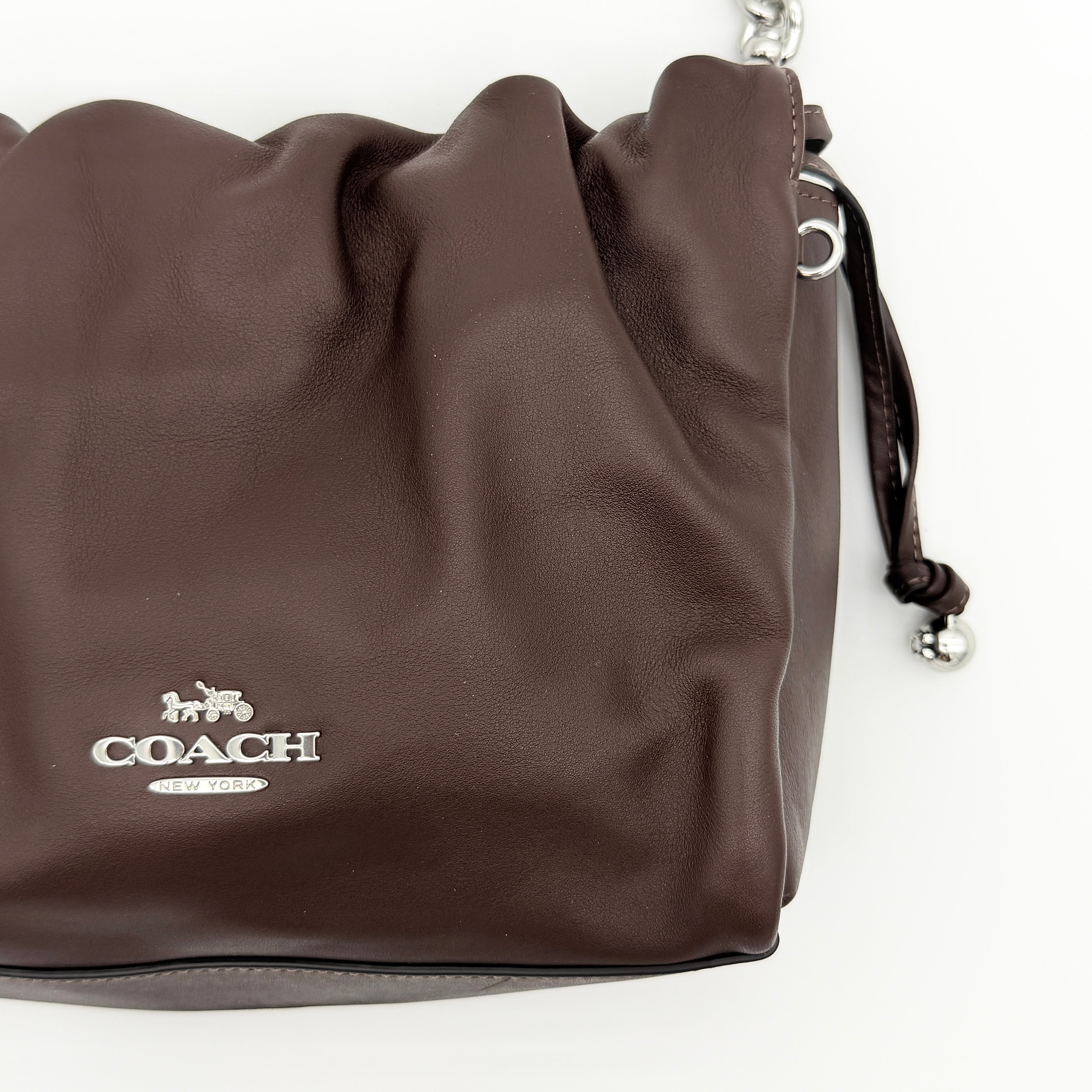 Coach Faye shoulder bag in brown leather with chunky silver-tone chain handle and detachable strap, displayed against a white background.