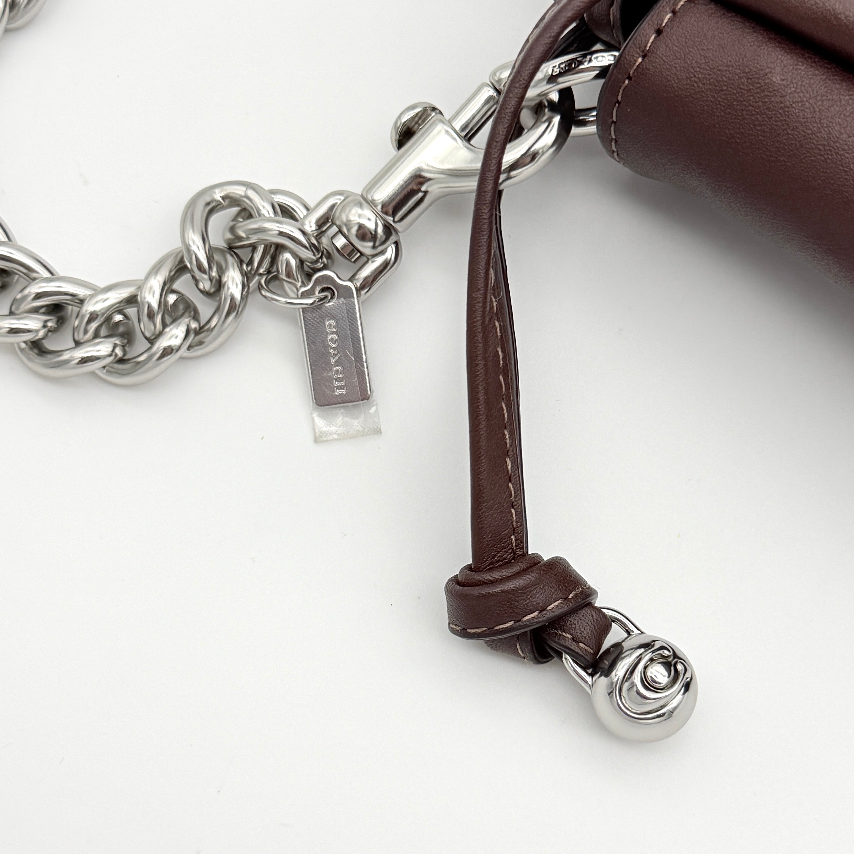 Coach Faye shoulder bag in brown leather with chunky silver-tone chain handle and detachable strap, displayed against a white background.