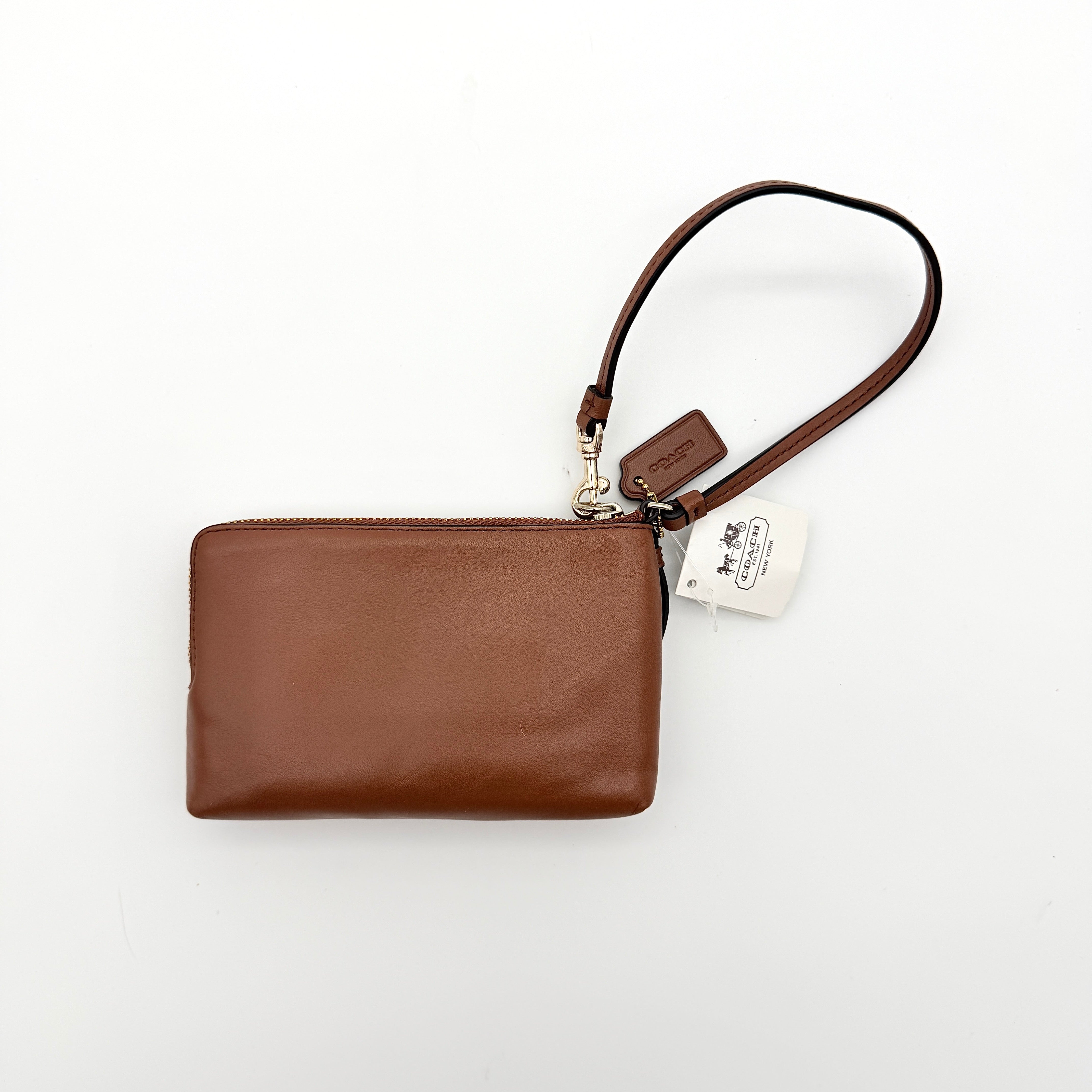 Coach Signature Double Zip Wristlet in brown leather with gold hardware and wrist strap, displayed with Coach cards.