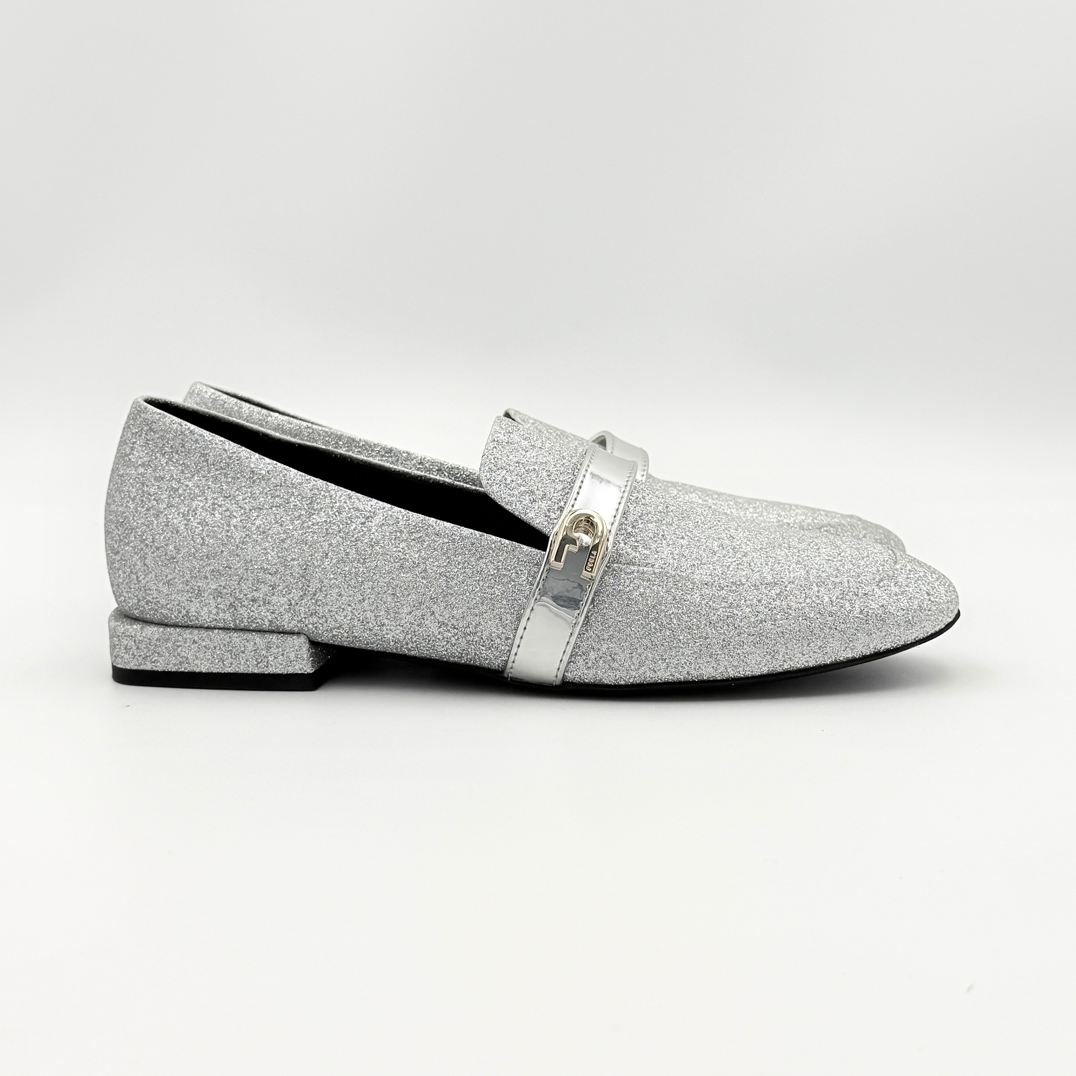 Furla 1927 T.20 loafers in silver microglitter with metallic strap and gold-tone detail, displayed in a three-quarter view.