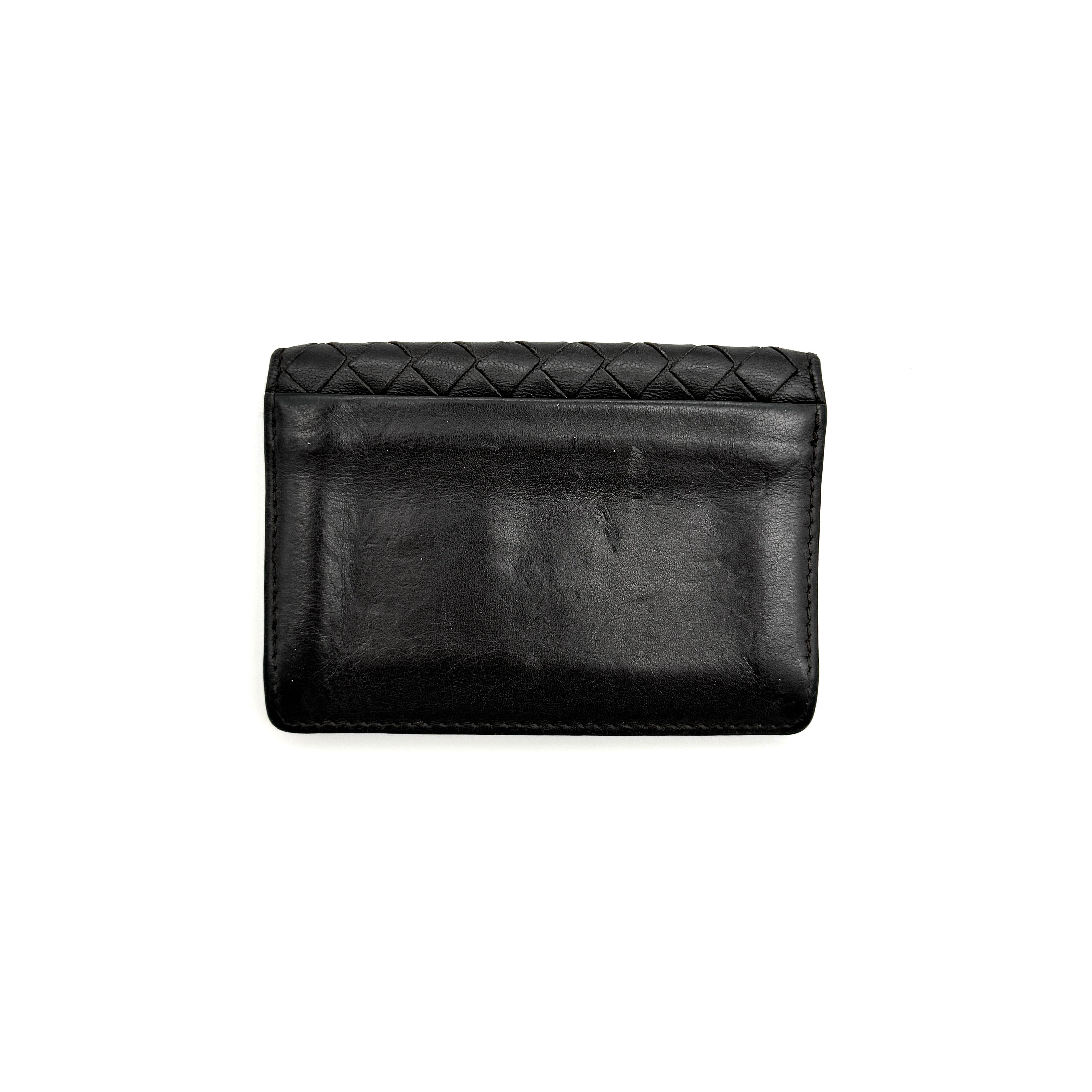 Bottega Veneta Intrecciato card case in black leather with woven front, photographed against a white background.