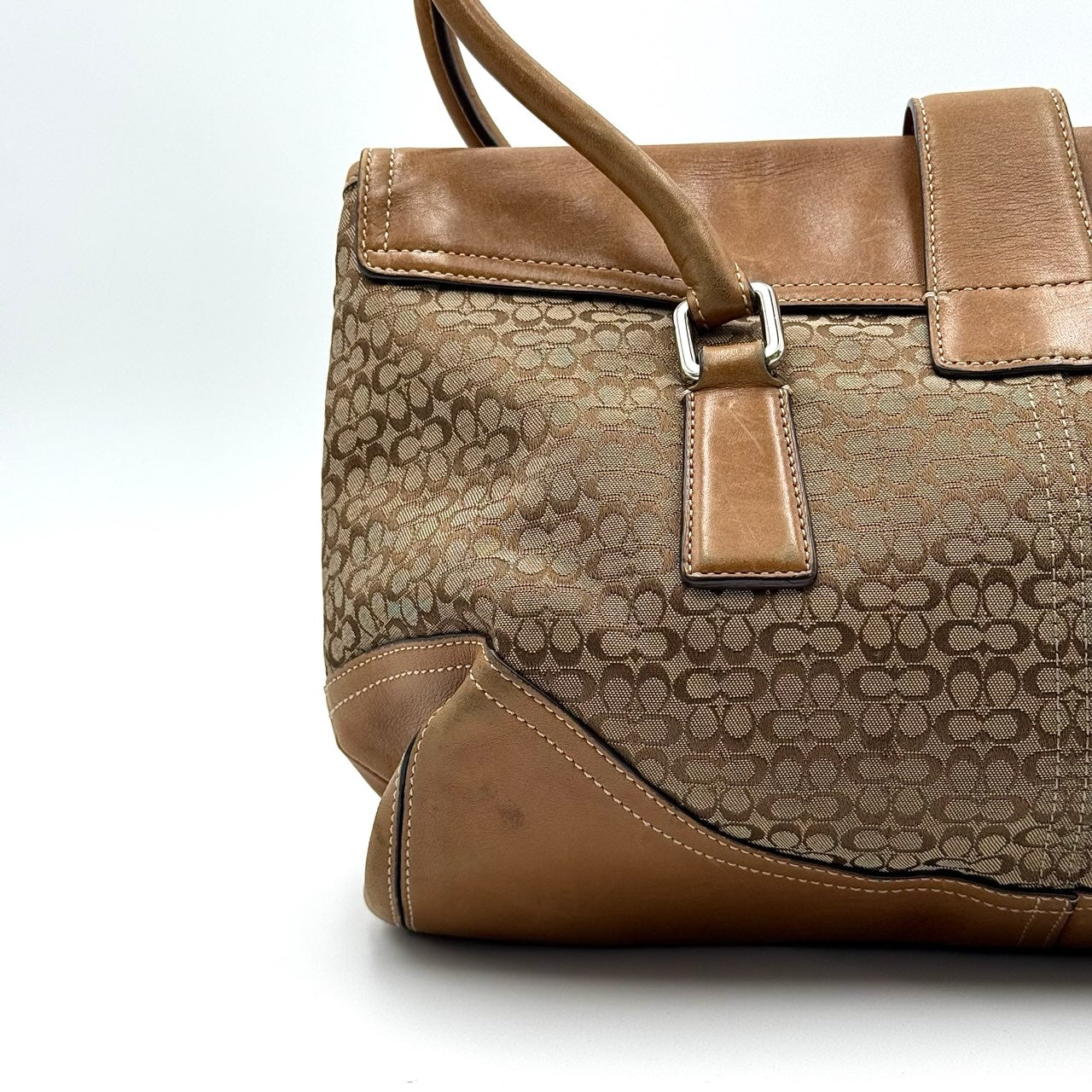 Coach Signature Soho shoulder bag in beige and tan canvas with leather trim and silver buckle.
