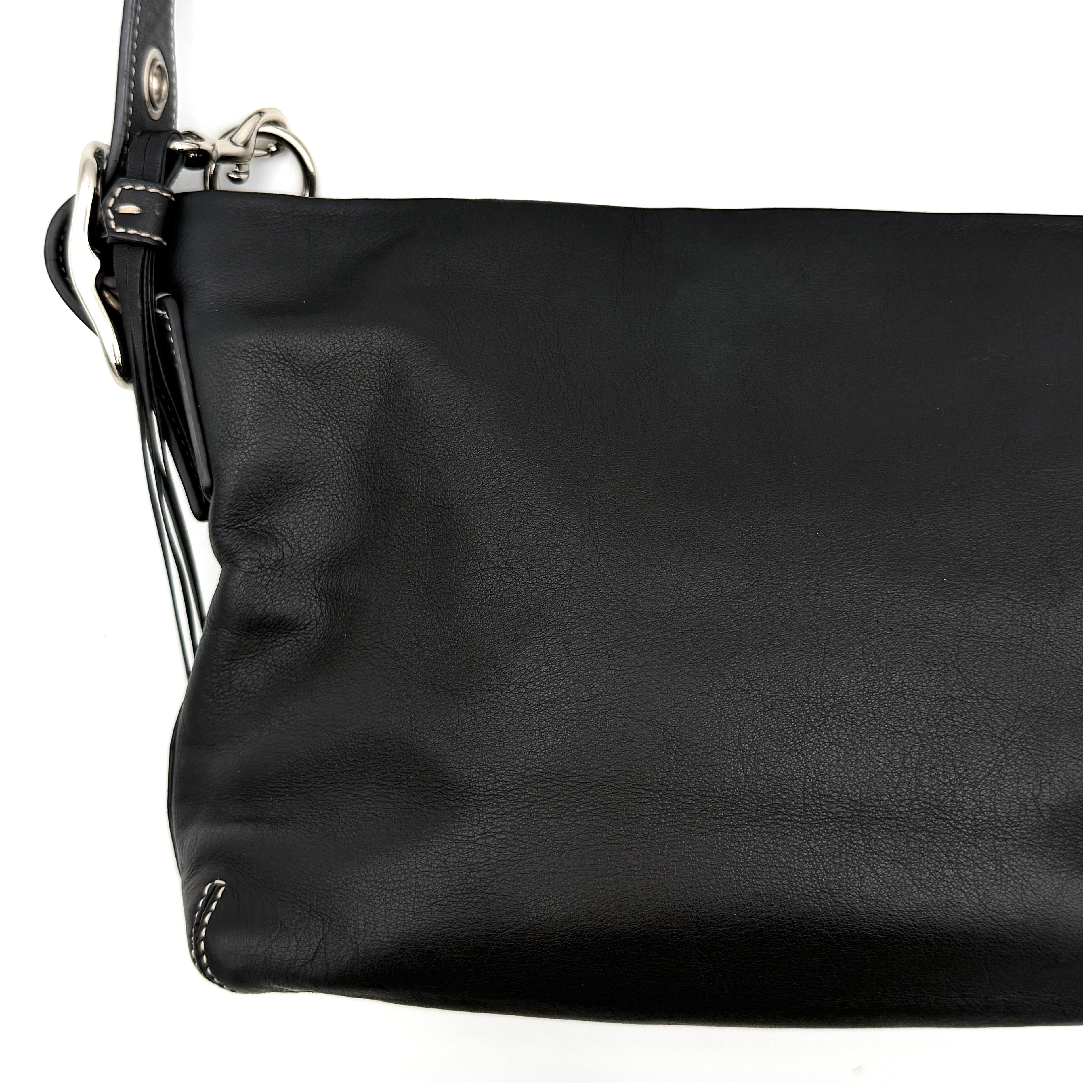 Coach Signature East West Shoulder Bag in black leather with silver hardware and contrast stitching, displayed on a white background.