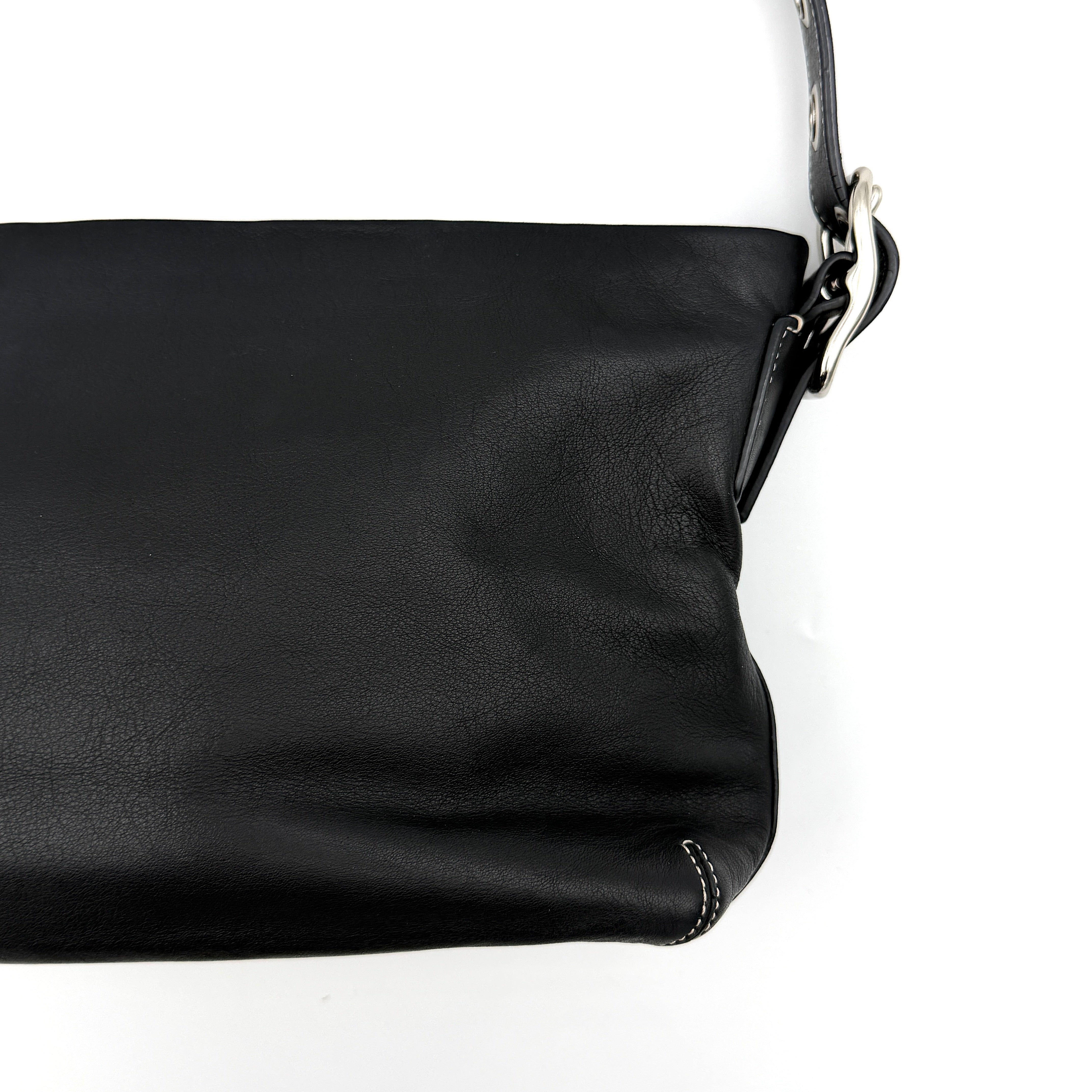 Coach Signature East West Shoulder Bag in black leather with silver hardware and contrast stitching, displayed on a white background.