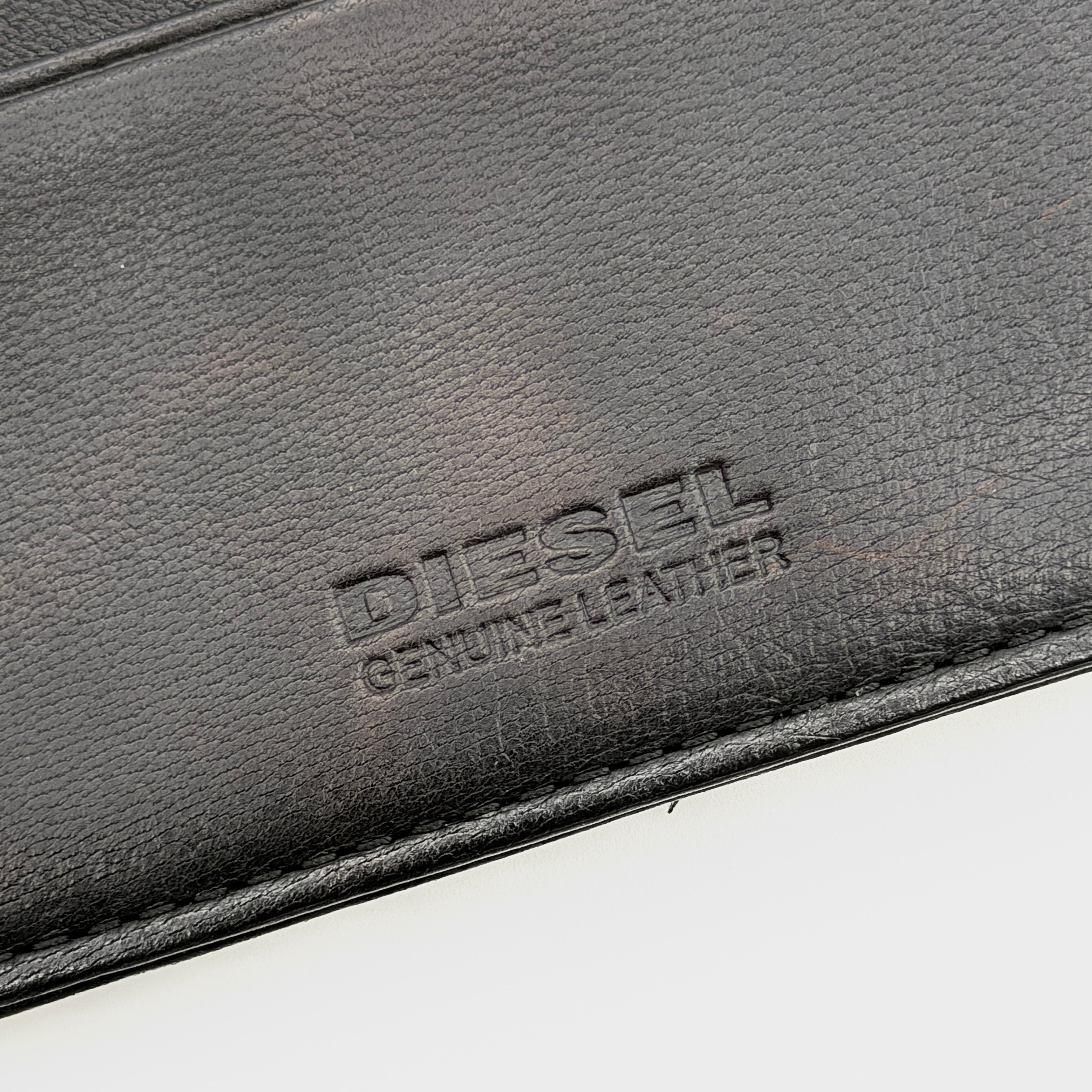 Diesel card case in white leather with bold black grommets and studs on the front.