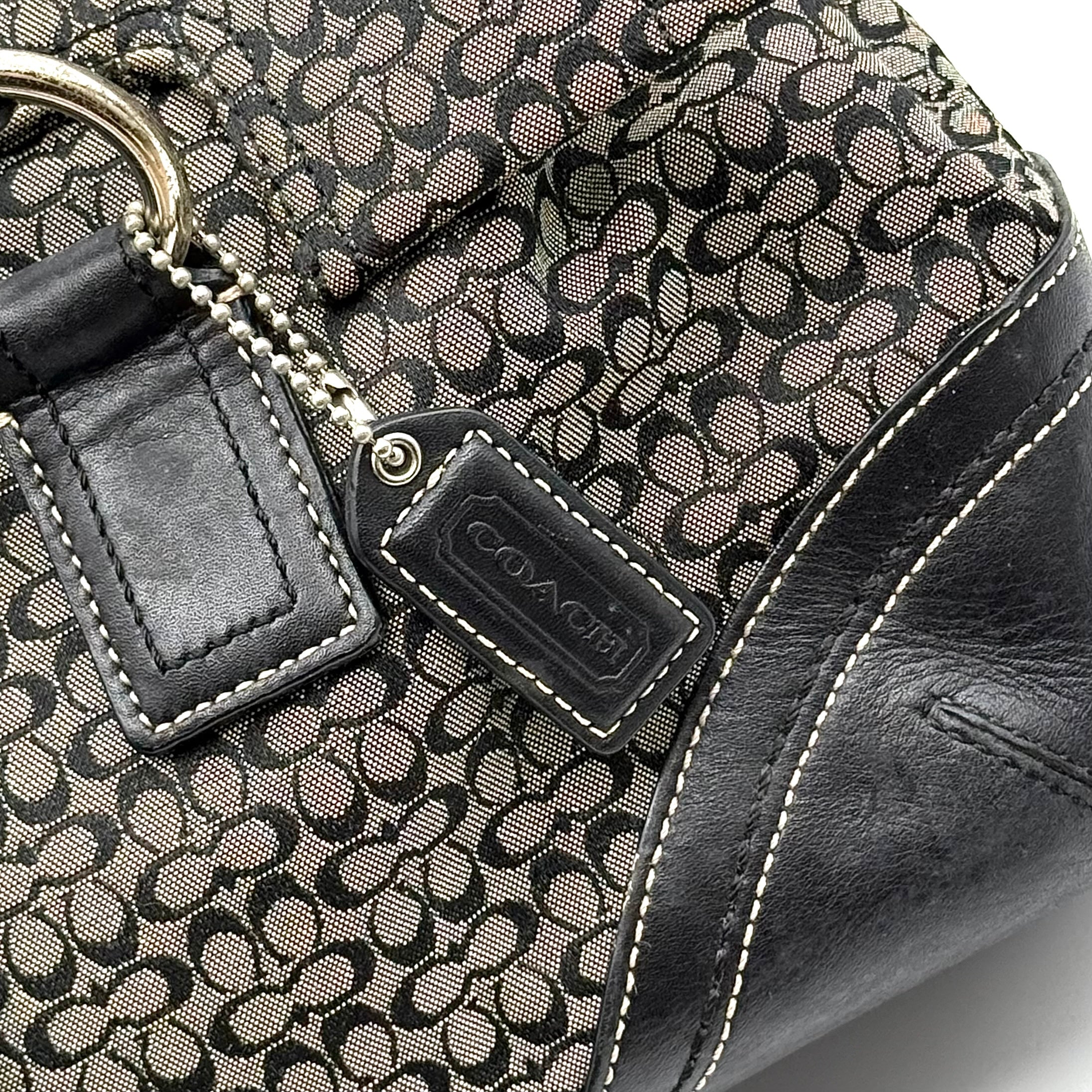Coach Soho shoulder bag in grey and black jacquard with leather trim and silver hardware, presented with double top handles.