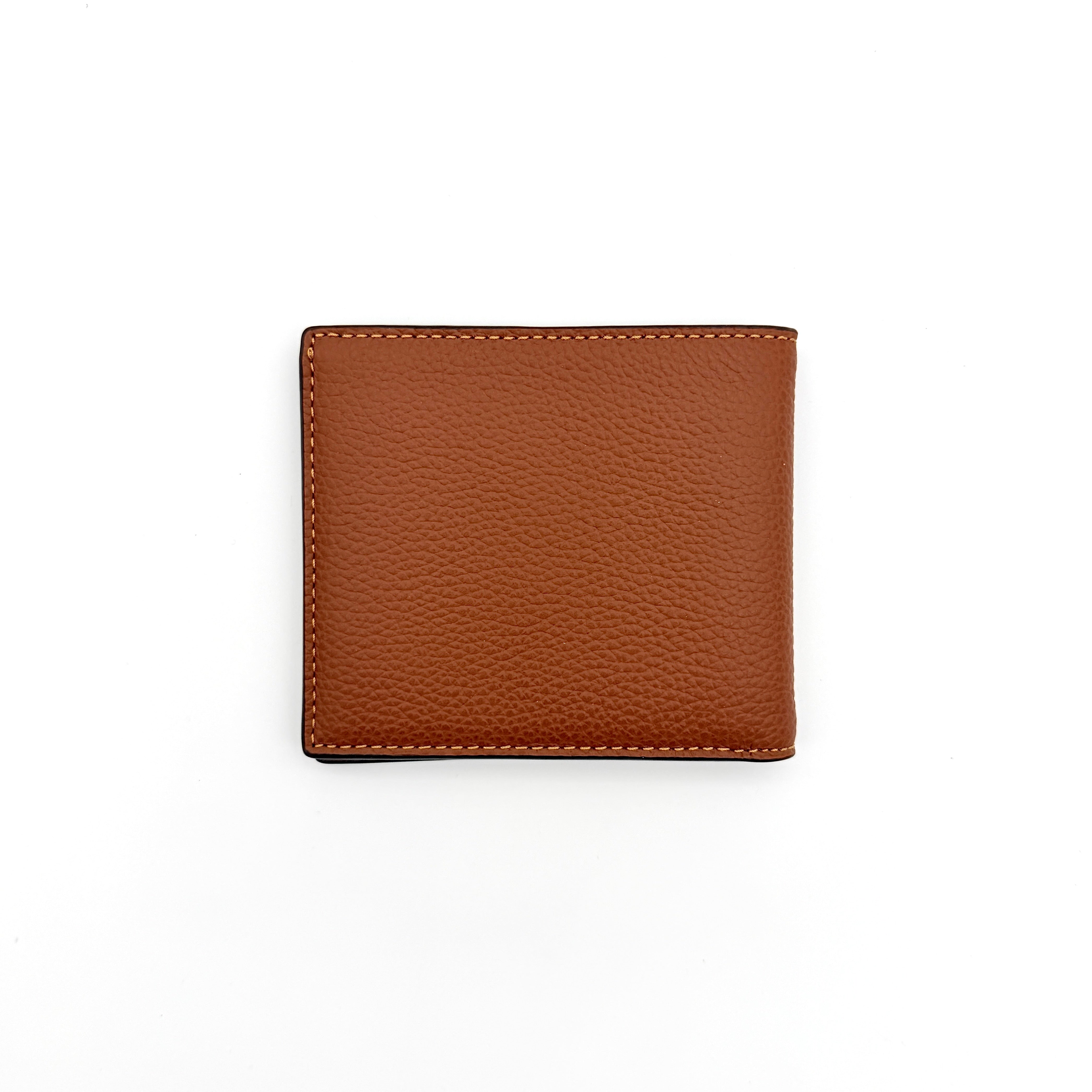 Coach slim billfold wallet in saddle brown pebbled leather with embossed logo and refined topstitch detailing.