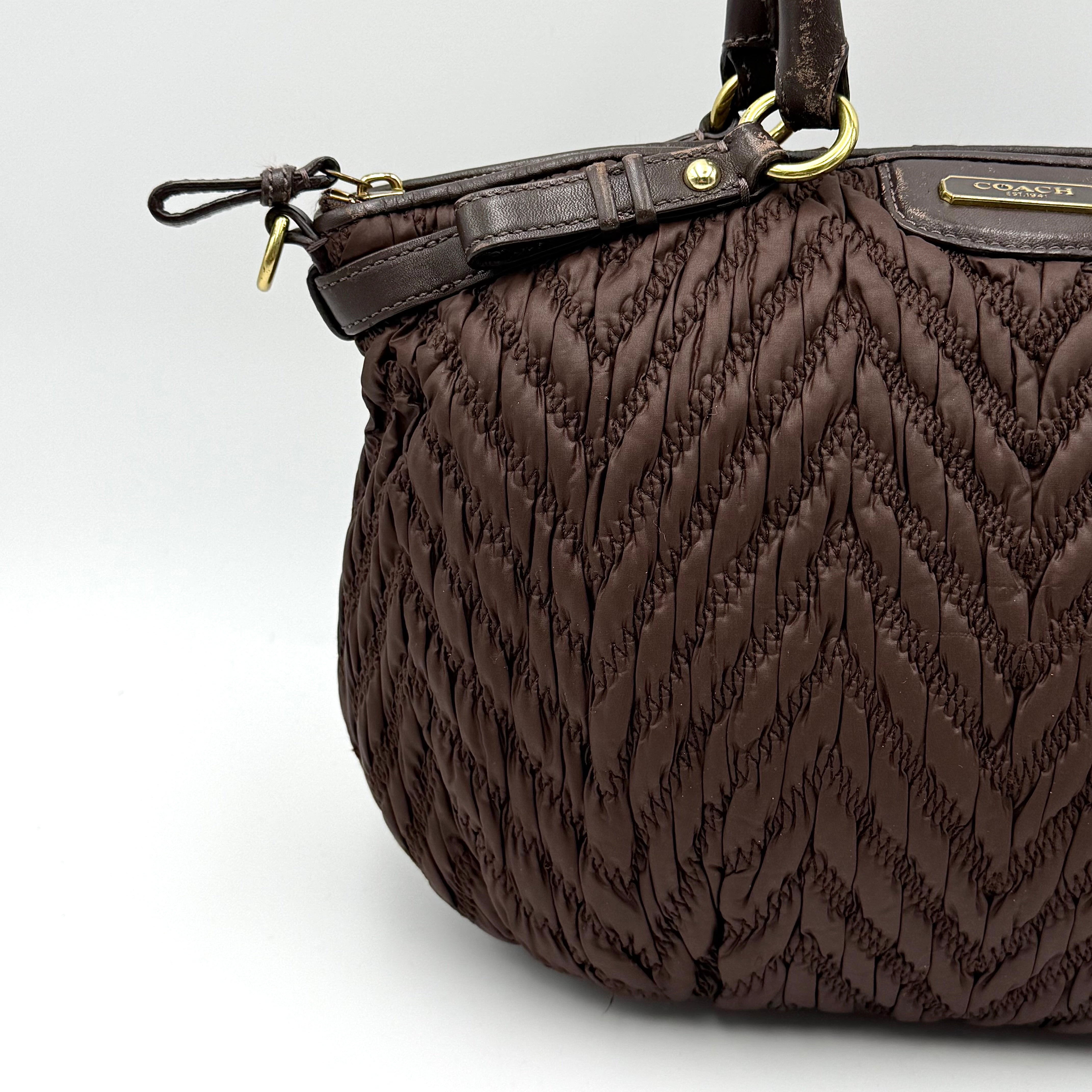 Front view of the Coach Madison Chevron 2Way brown quilted nylon shoulder bag with rolled leather handles and gold-tone hardware.