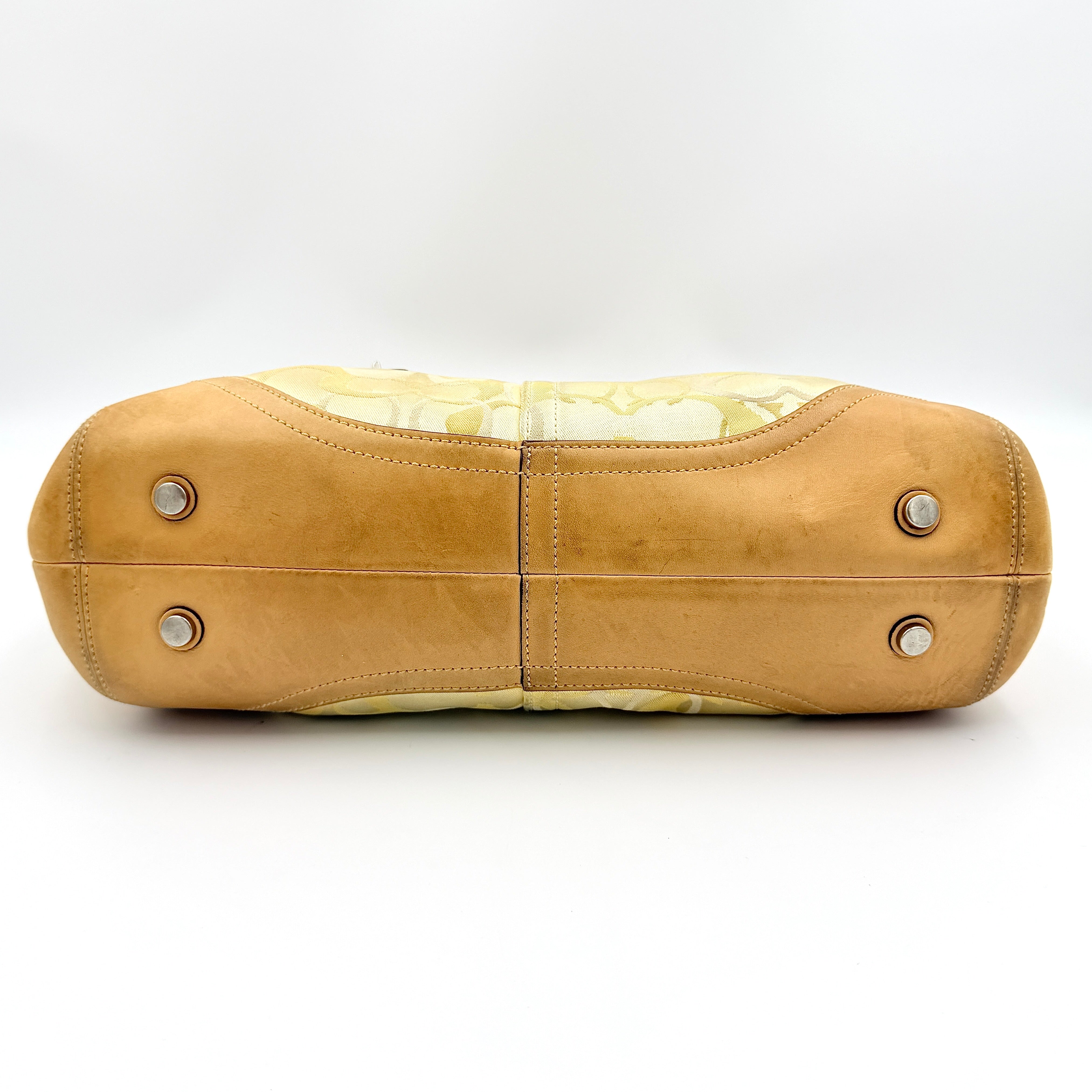 Coach Soho shoulder bag in yellow signature optic fabric with tan leather trim and silver hardware, shown with double handles.
