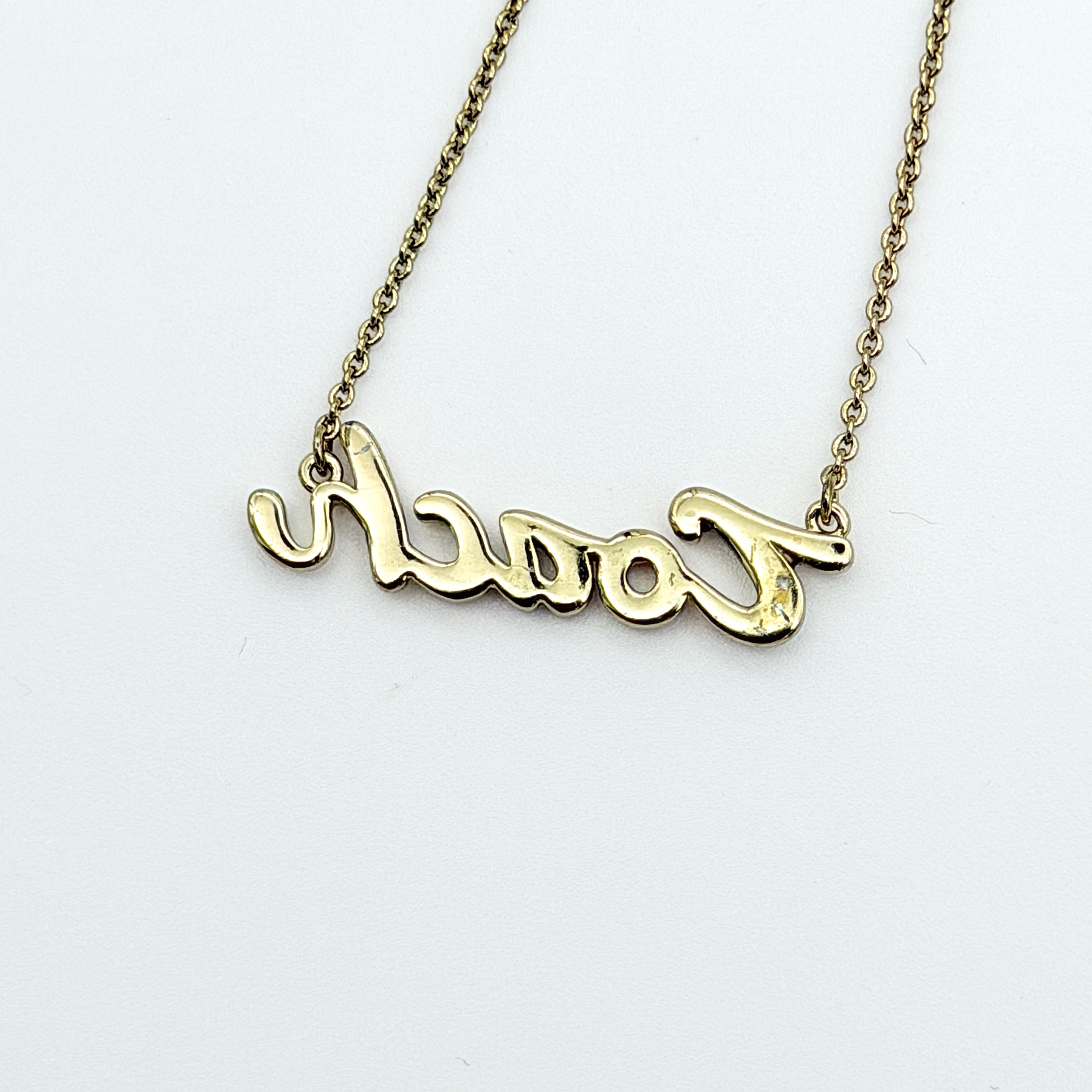 Coach Signature Script Rainbow Necklace with multicolour crystals set on a gold-tone chain, displayed in its original Coach box.