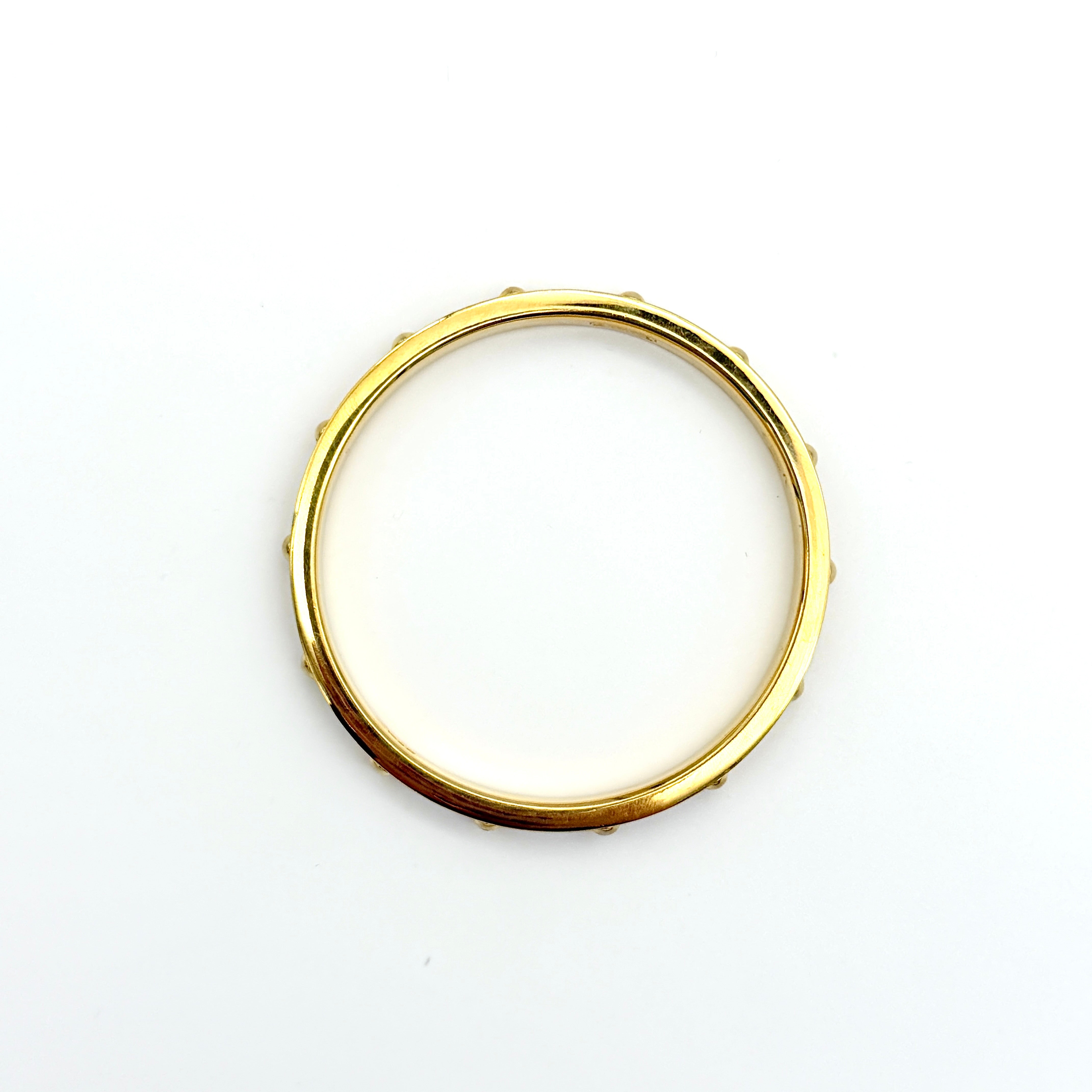 Coach gold studded bangle bracelet with textured finish and rounded gold studs, photographed against a clean background.