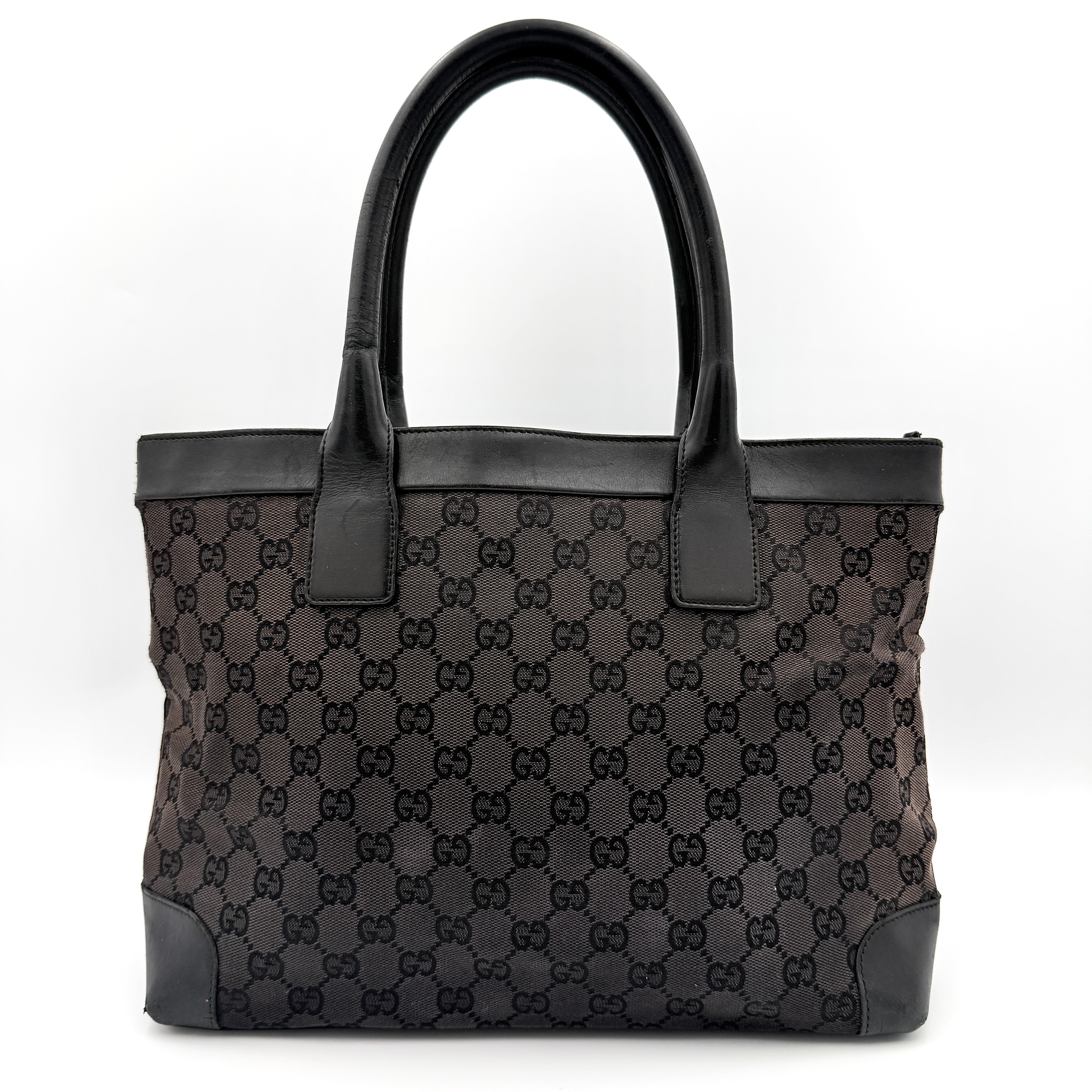 Gucci GG Monogram Leather Tote Bag in black canvas and leather, with structured top handles and allover GG motif.