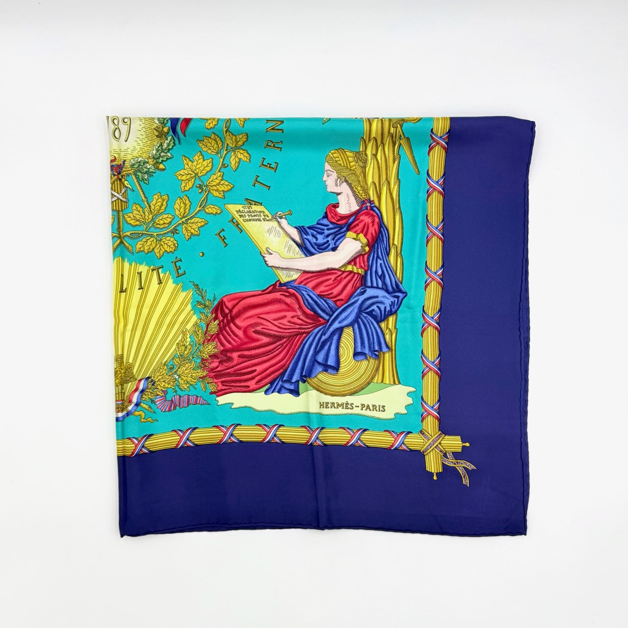 Hermès Liberté Égalité Fraternité silk scarf in vibrant blue with classical French motifs and tricolour accents.