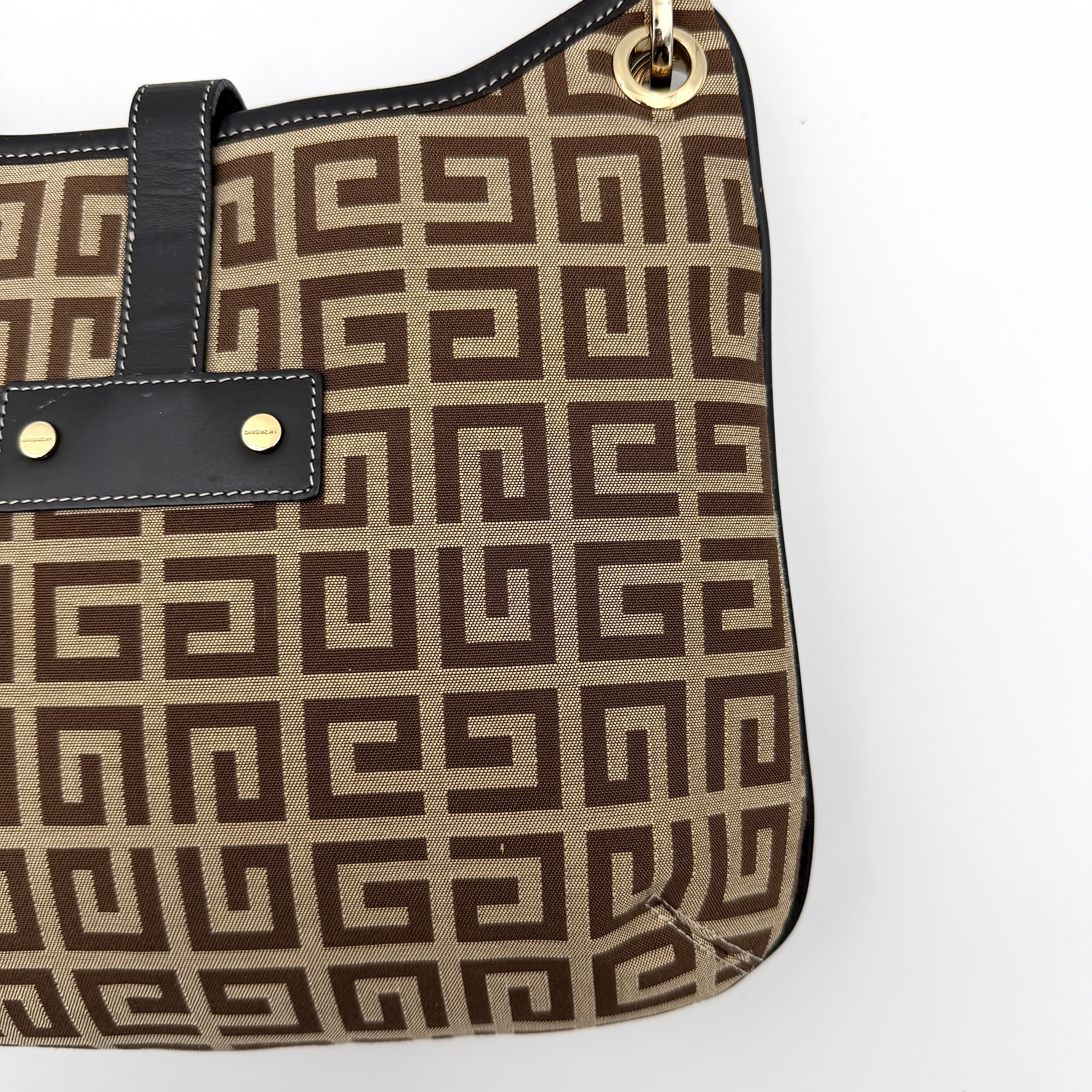 The Givenchy Monogram Hobo Shoulder Bag in brown canvas with black leather trim and gold hardware, displayed front-facing.