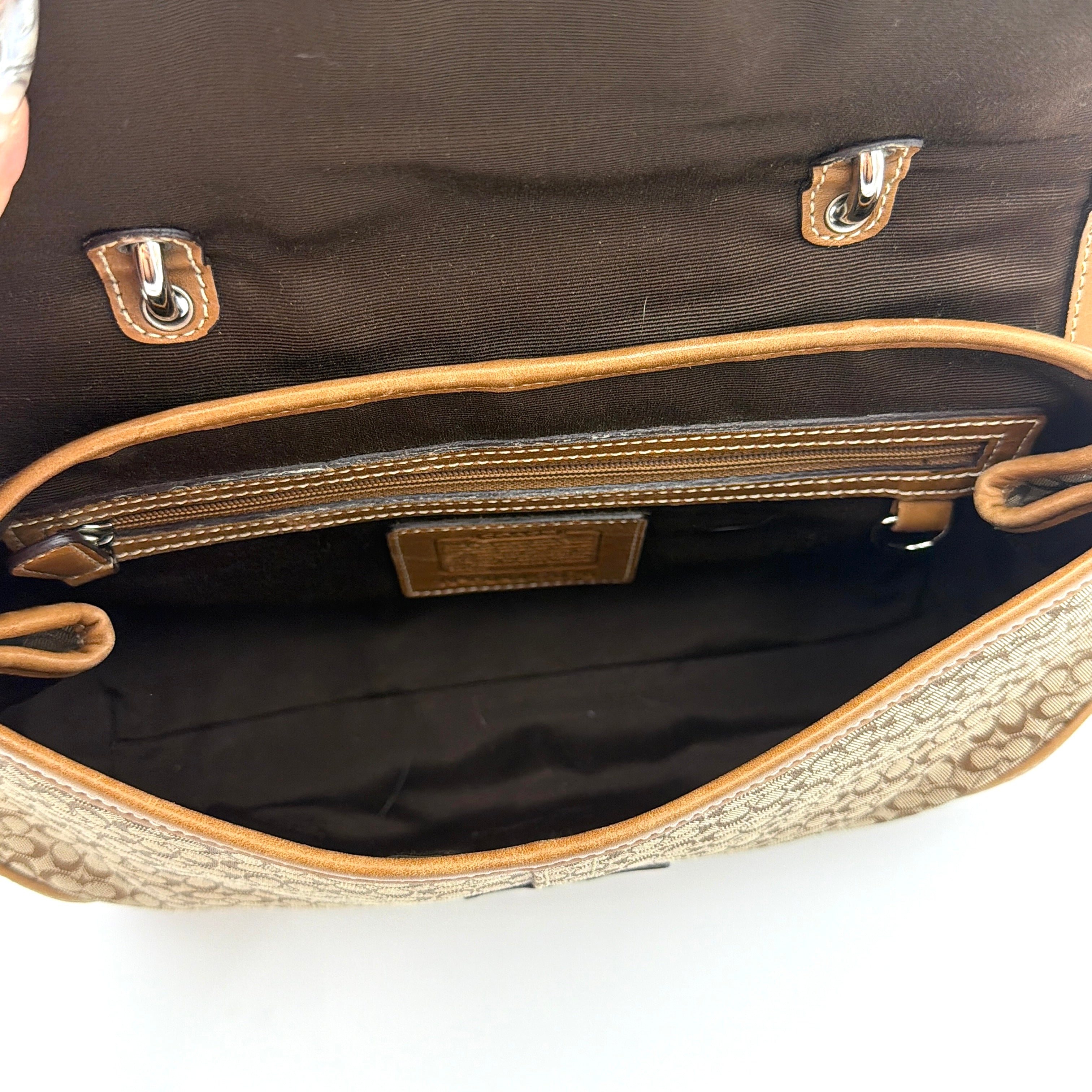 Coach Soho Shoulder Bag in beige and tan monogram jacquard with caramel leather trim, featuring silver hardware and a signature buckle flap.