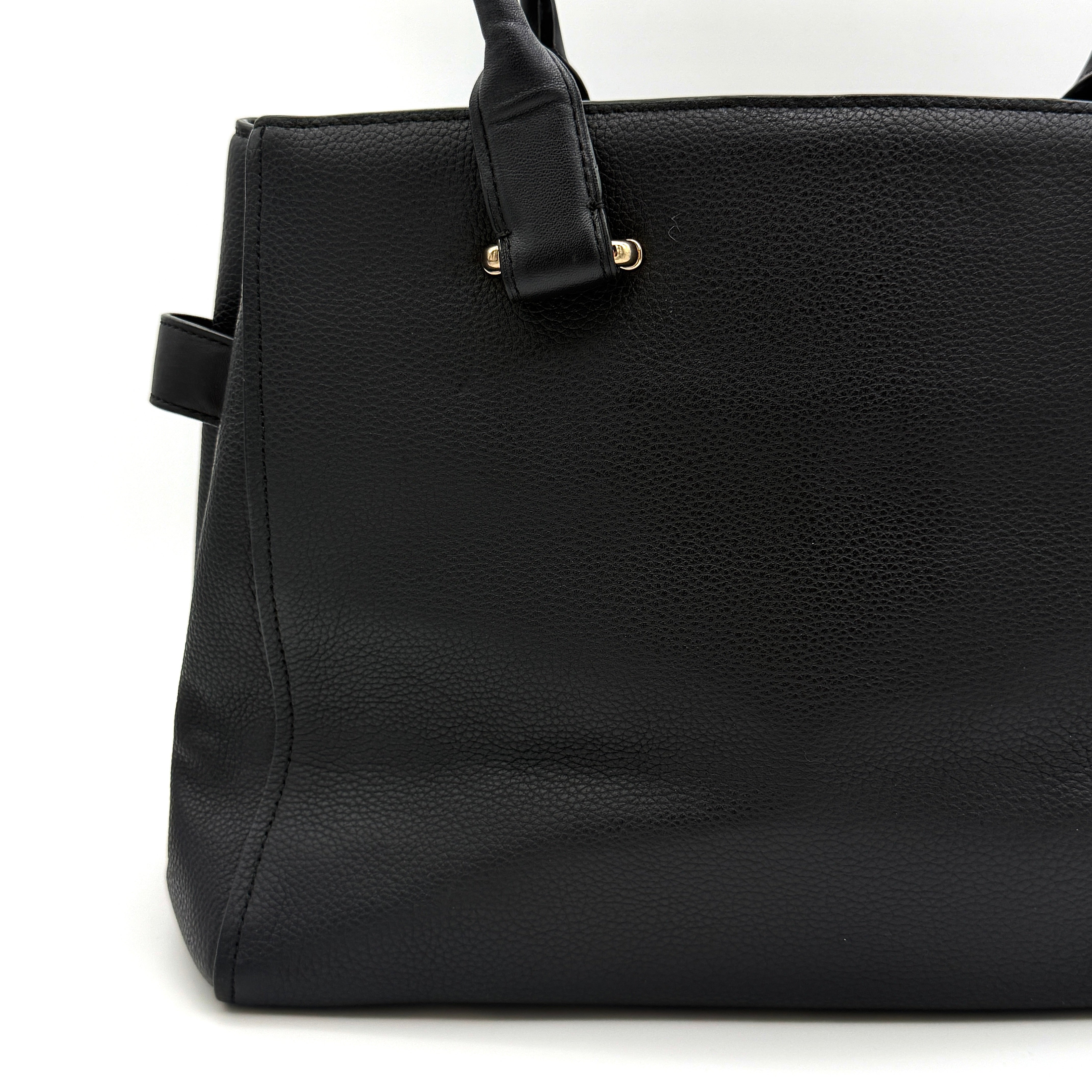Coach Swagger Carryall in black pebbled leather with gold-tone hardware and double turnlock detail, shown from the front.