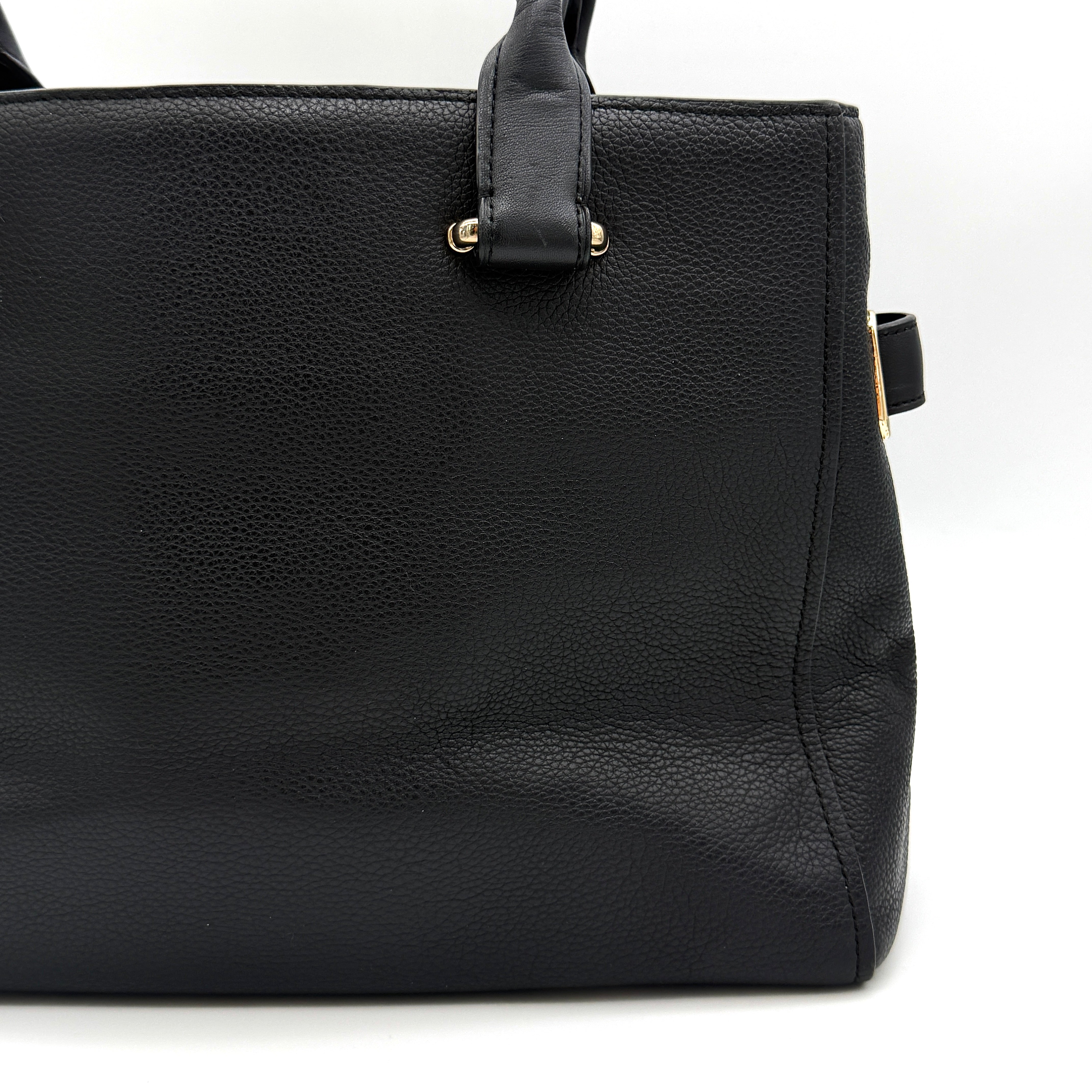 Coach Swagger Carryall in black pebbled leather with gold-tone hardware and double turnlock detail, shown from the front.