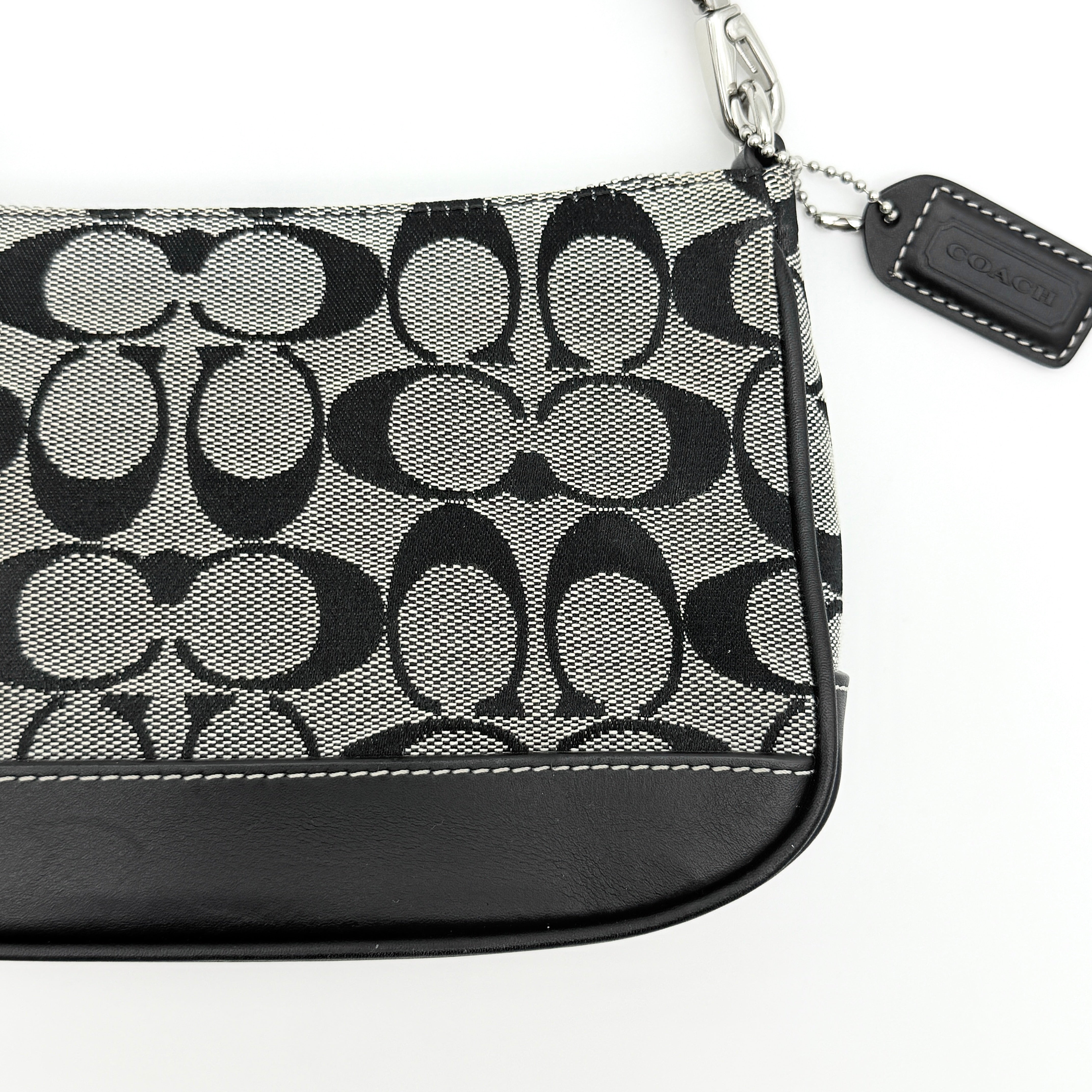 Coach Y2K demi shoulder bag in grey and black signature jacquard with black leather trim and silver hardware, shown with top handle and branded tag.