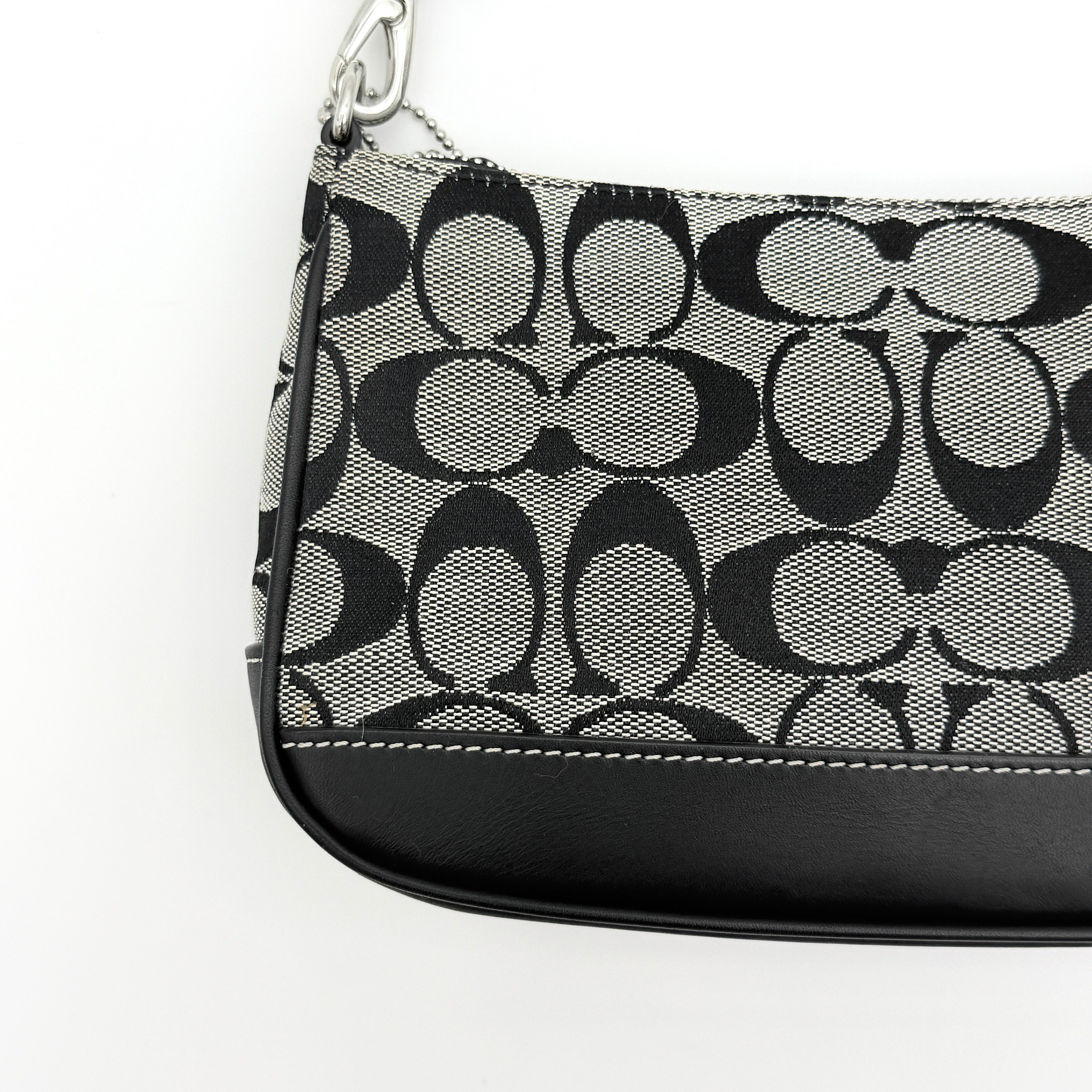 Coach Y2K demi shoulder bag in grey and black signature jacquard with black leather trim and silver hardware, shown with top handle and branded tag.