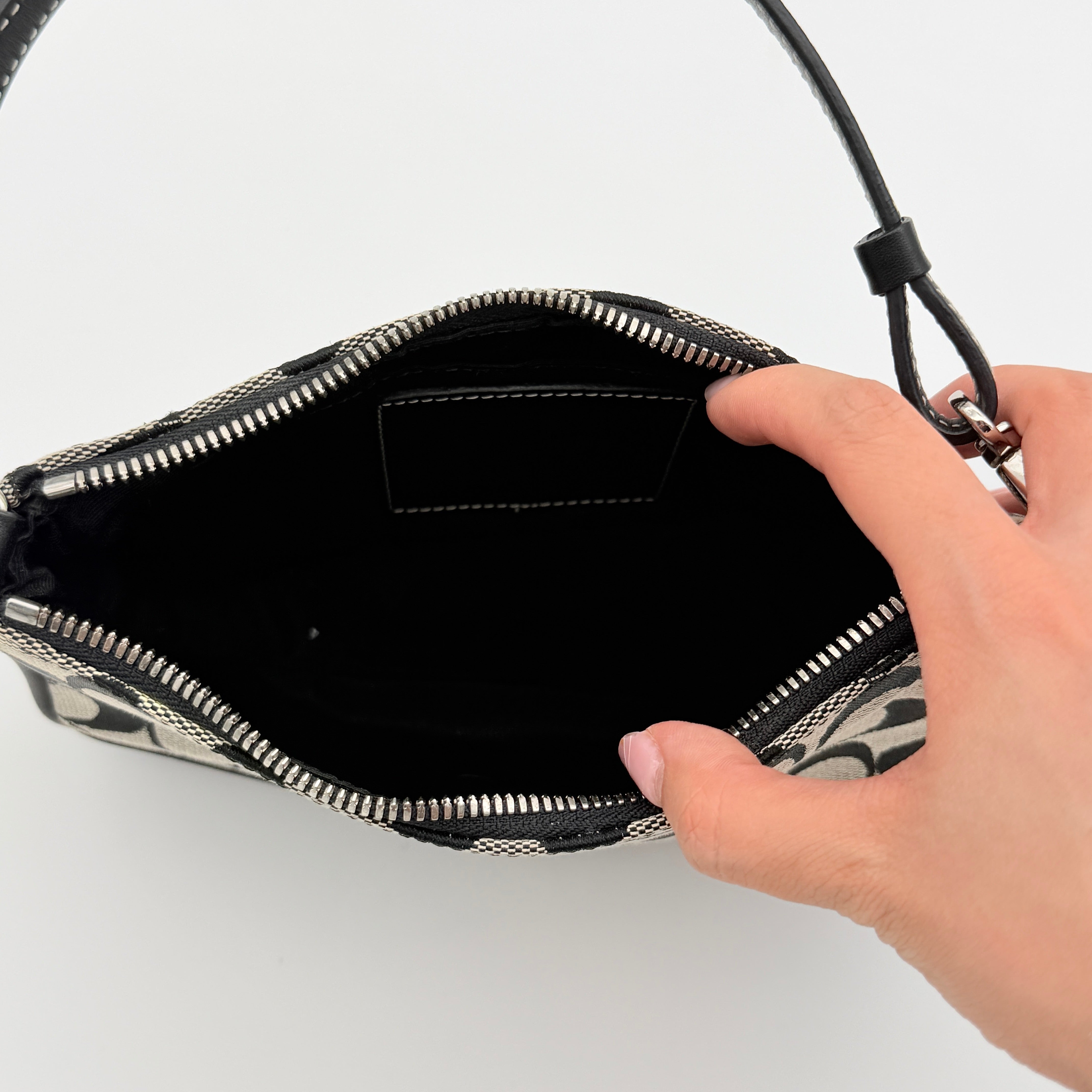 Coach Y2K demi shoulder bag in grey and black signature jacquard with black leather trim and silver hardware, shown with top handle and branded tag.