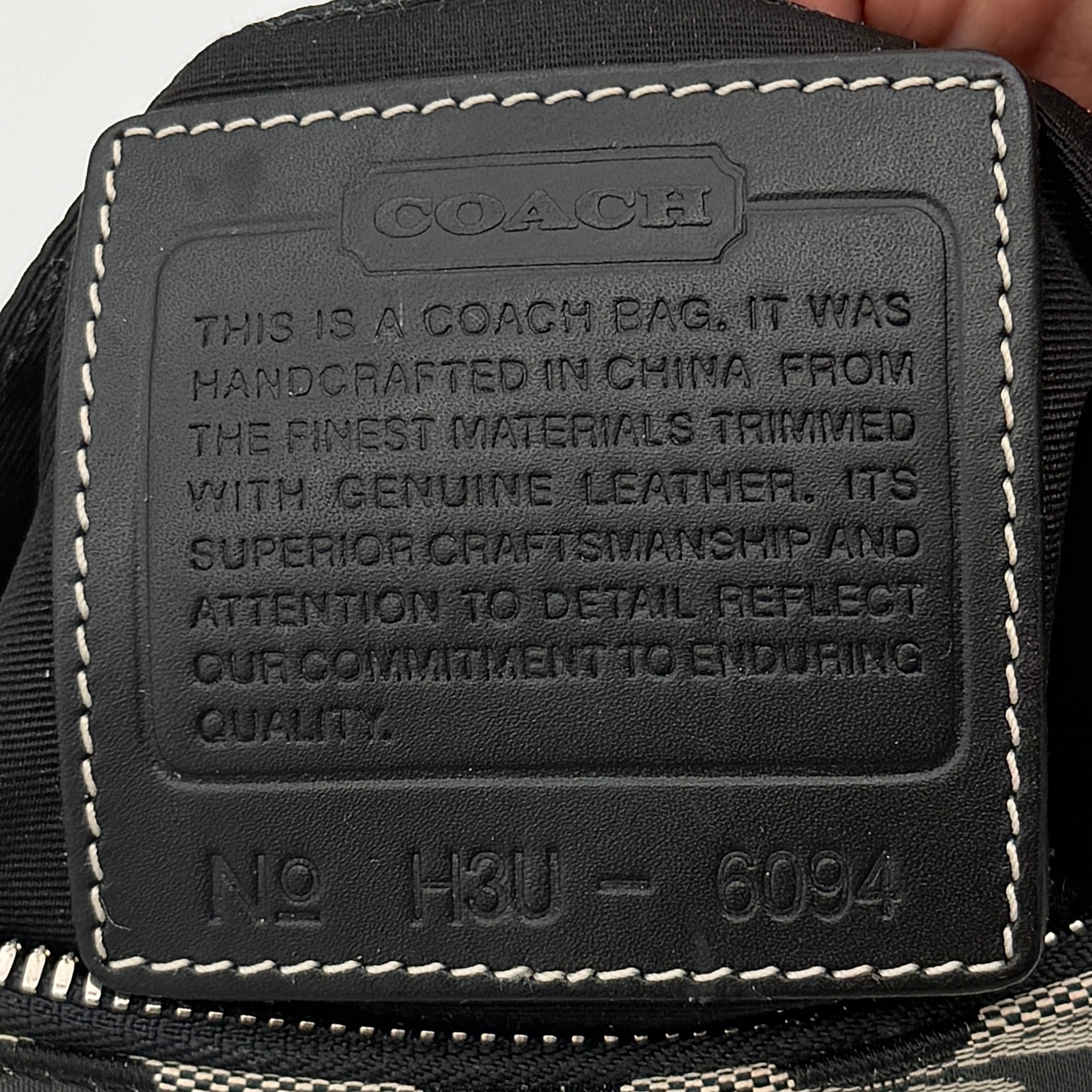 Coach Y2K demi shoulder bag in grey and black signature jacquard with black leather trim and silver hardware, shown with top handle and branded tag.
