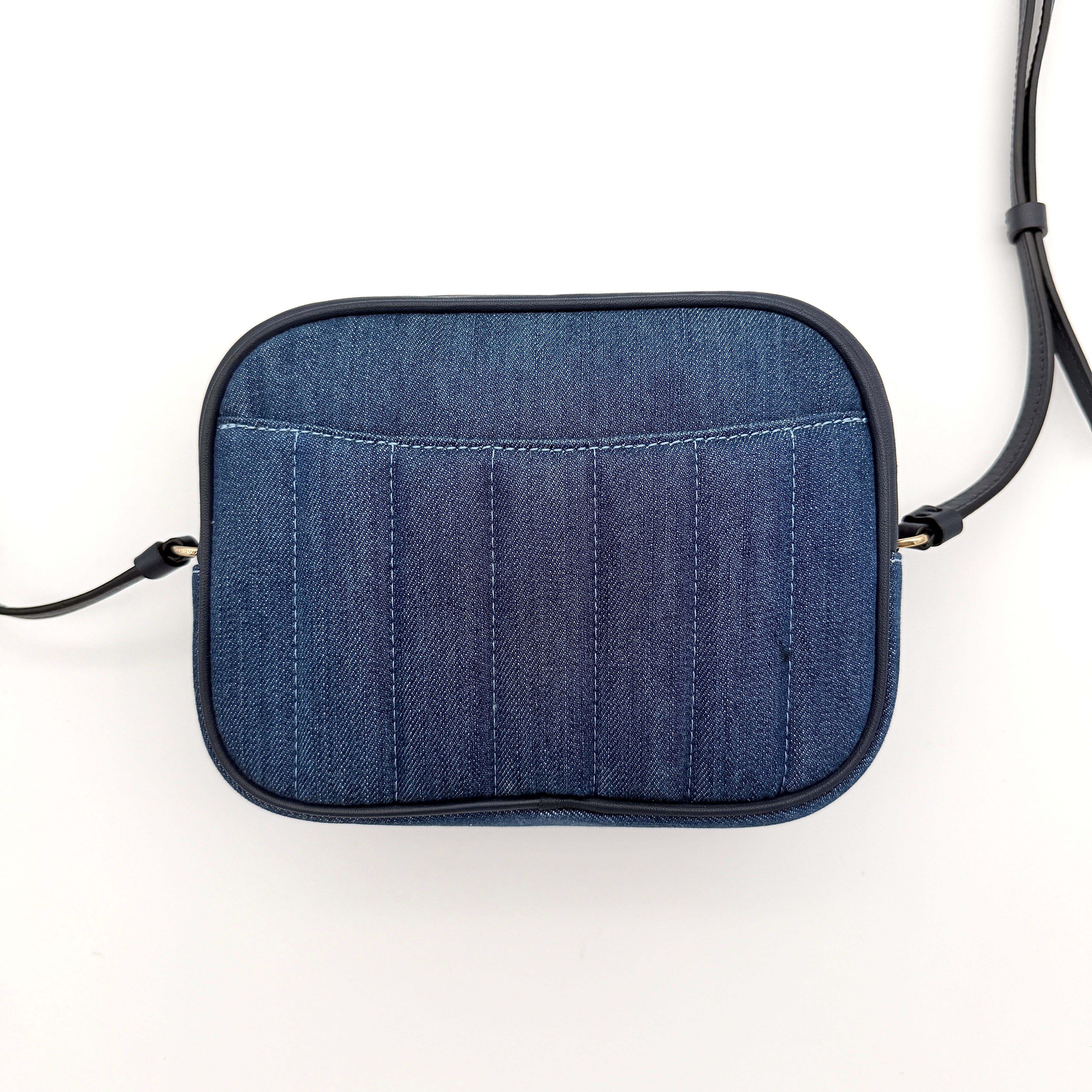Coach Jamie Mini Camera Bag in quilted blue denim with navy leather trim and gold hardware, shown with its adjustable crossbody strap.