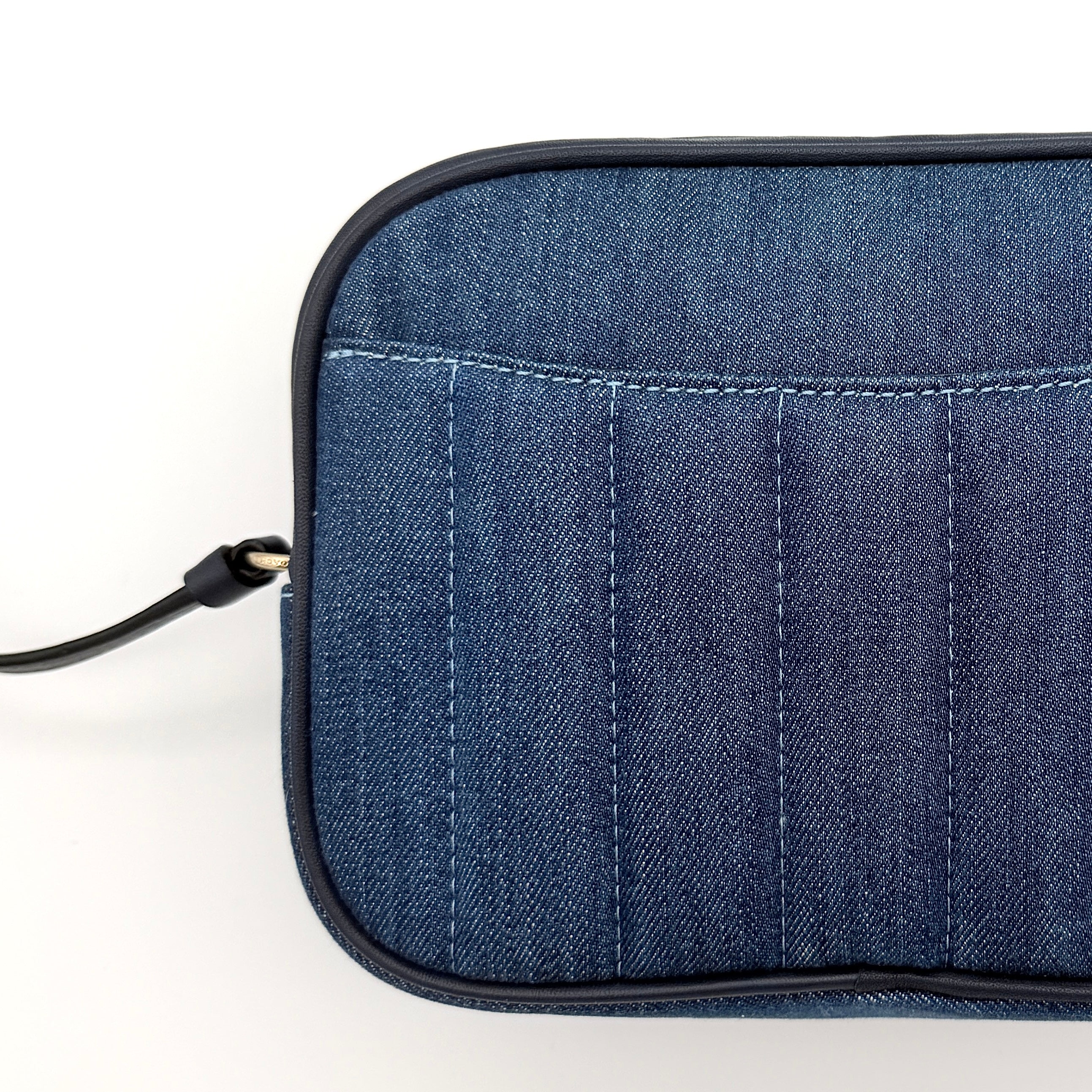 Coach Jamie Mini Camera Bag in quilted blue denim with navy leather trim and gold hardware, shown with its adjustable crossbody strap.