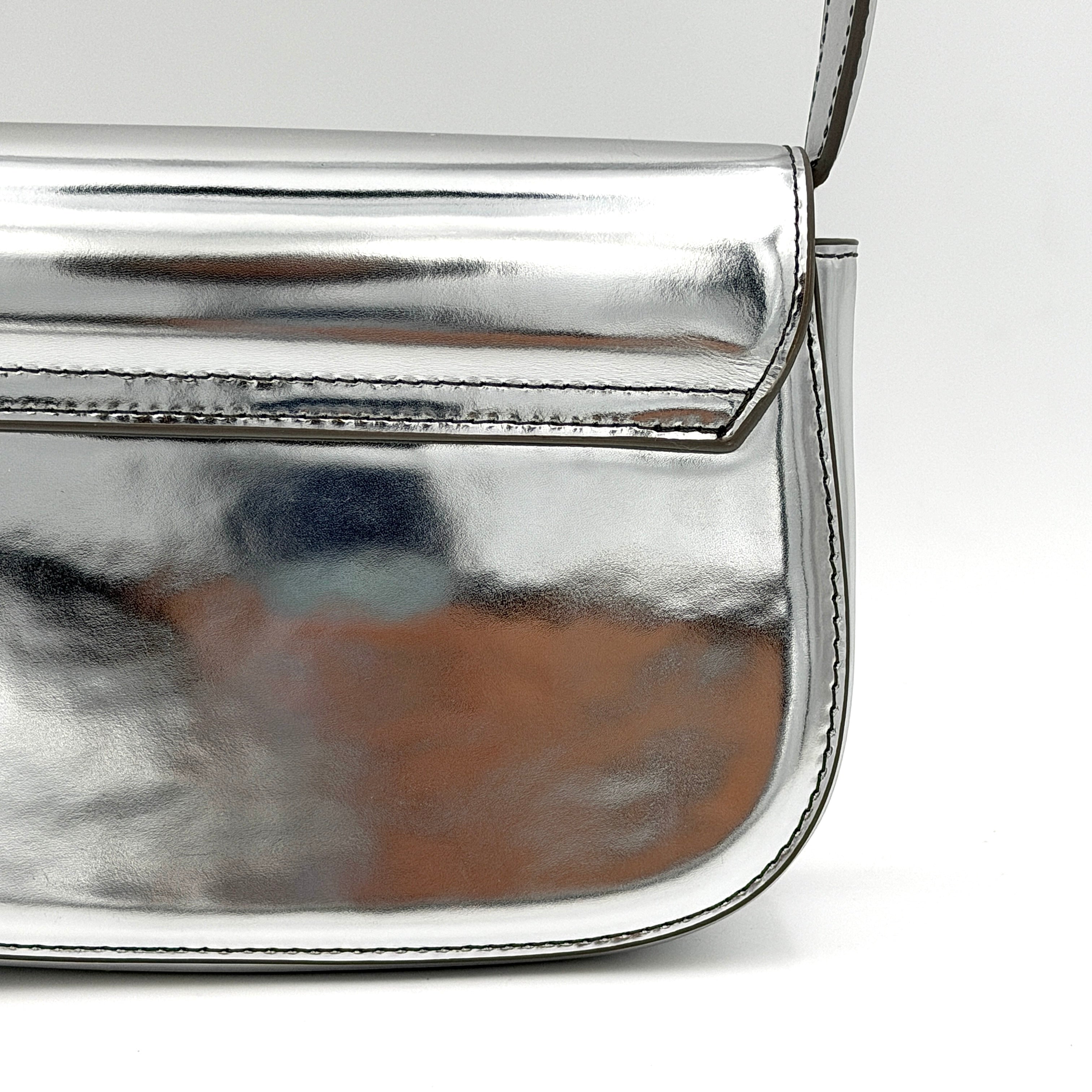 Diesel 1DR 2Way metallic silver shoulder bag with sculptural D logo and detachable strap displayed against a plain background.