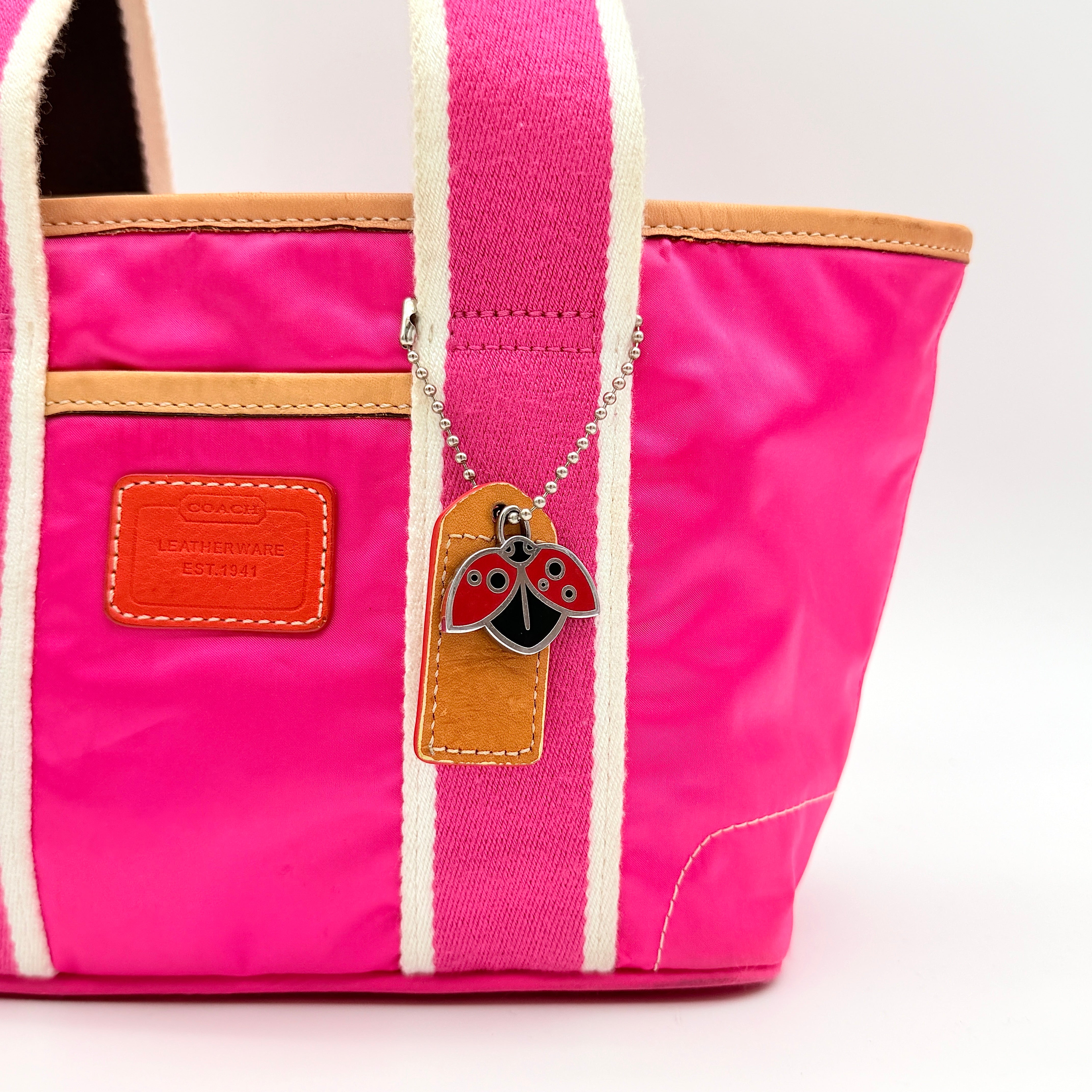 Coach Hampton Mini Tote Bag in hot pink nylon with canvas straps, leather trim, and ladybug charm.