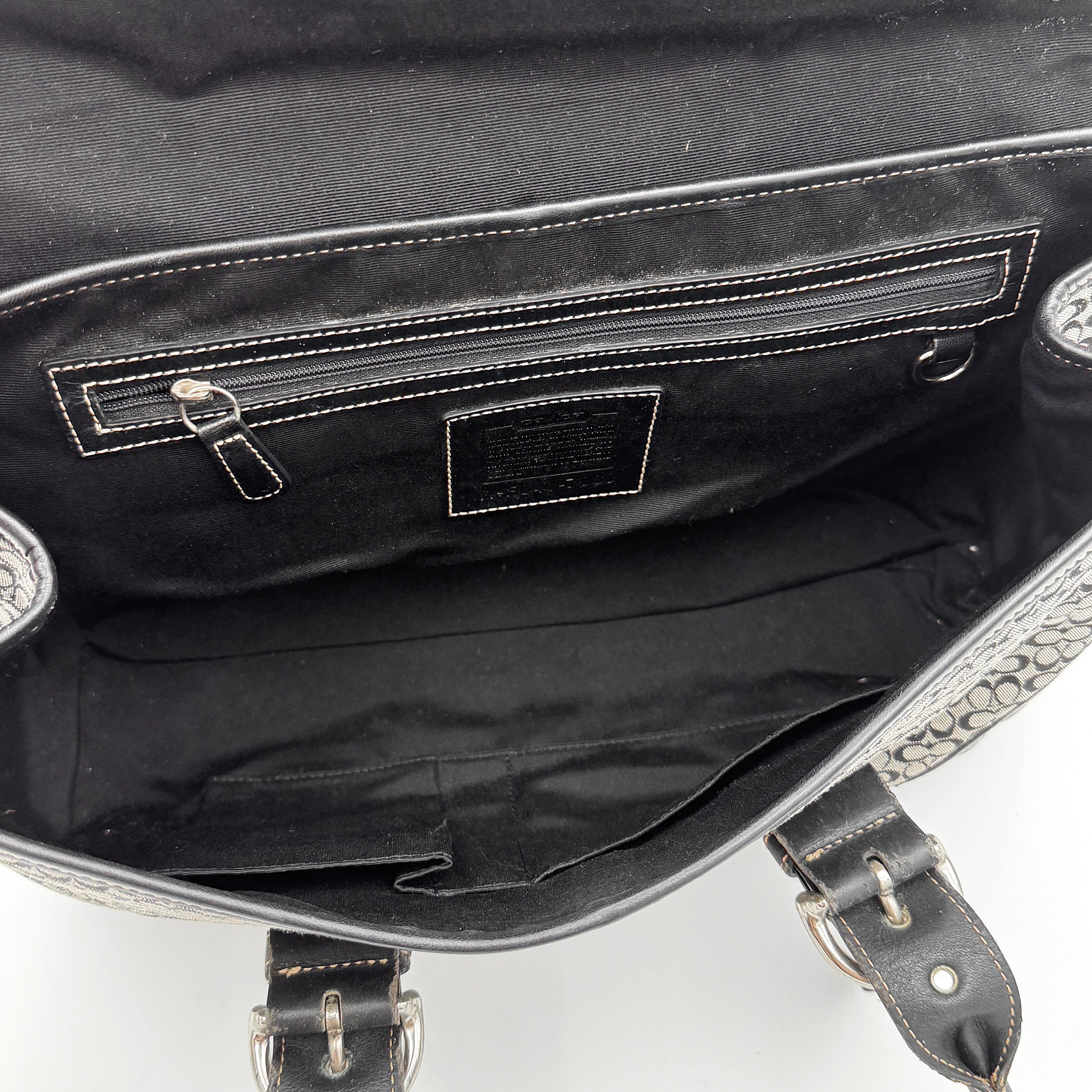 Coach Soho Hampton satchel in grey and black signature jacquard with black leather trim and silver-tone buckle details, presented upright with dual rolled handles.