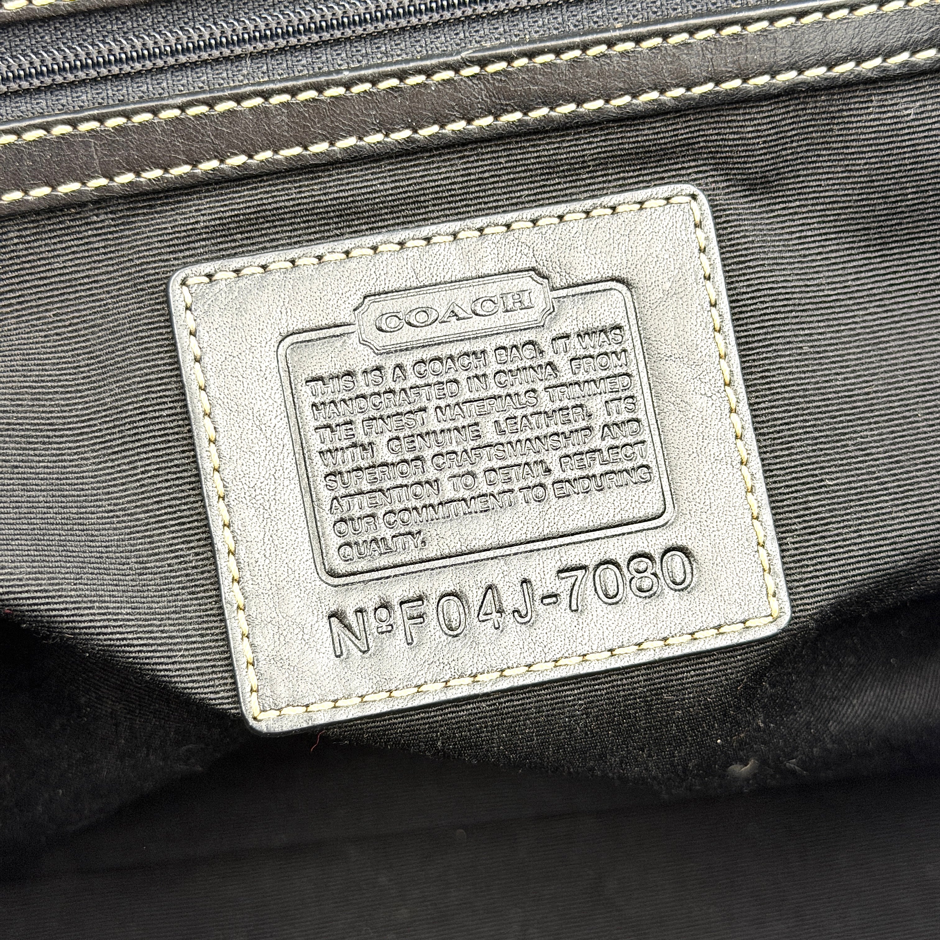 Coach Soho Hampton satchel in grey and black signature jacquard with black leather trim and silver-tone buckle details, presented upright with dual rolled handles.