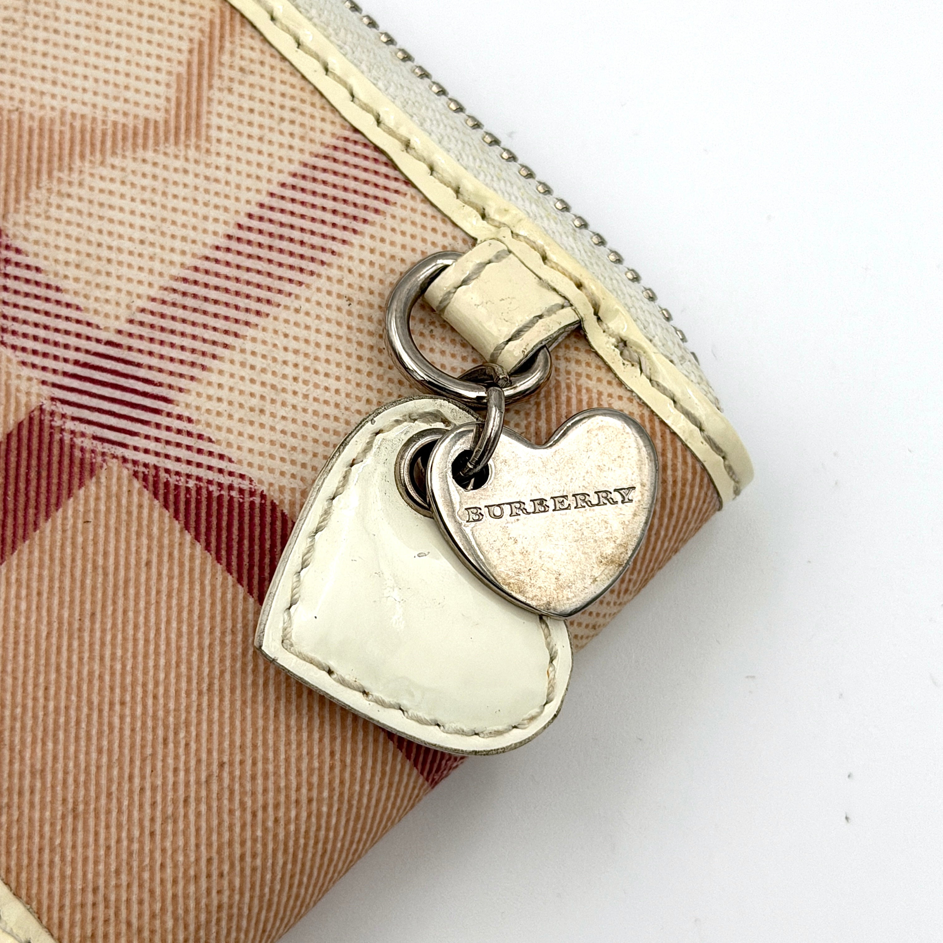 Burberry Heart Nova Check coin case in beige canvas with ivory leather trim and heart charms on the zipper pull.