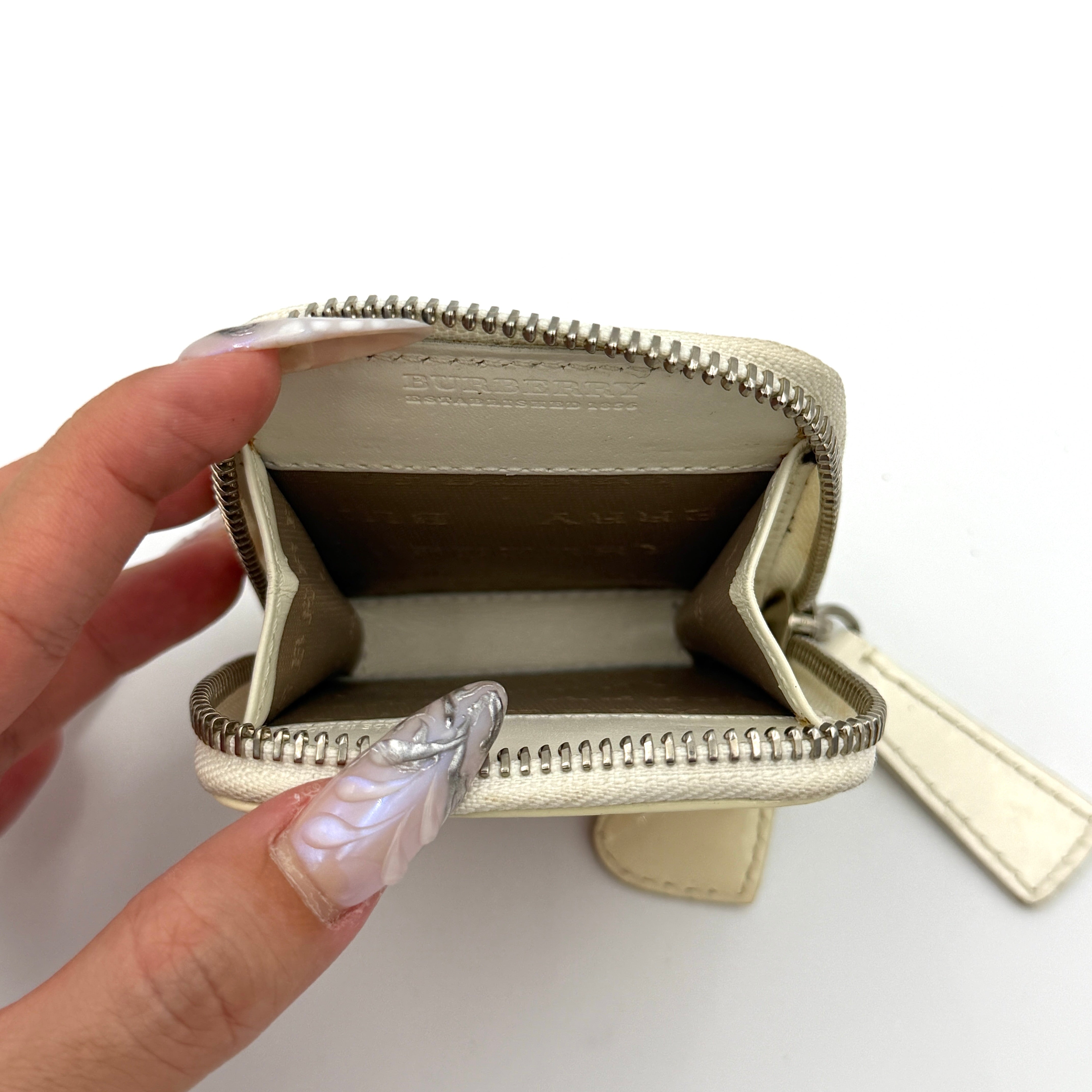 Burberry Heart Nova Check coin case in beige canvas with ivory leather trim and heart charms on the zipper pull.