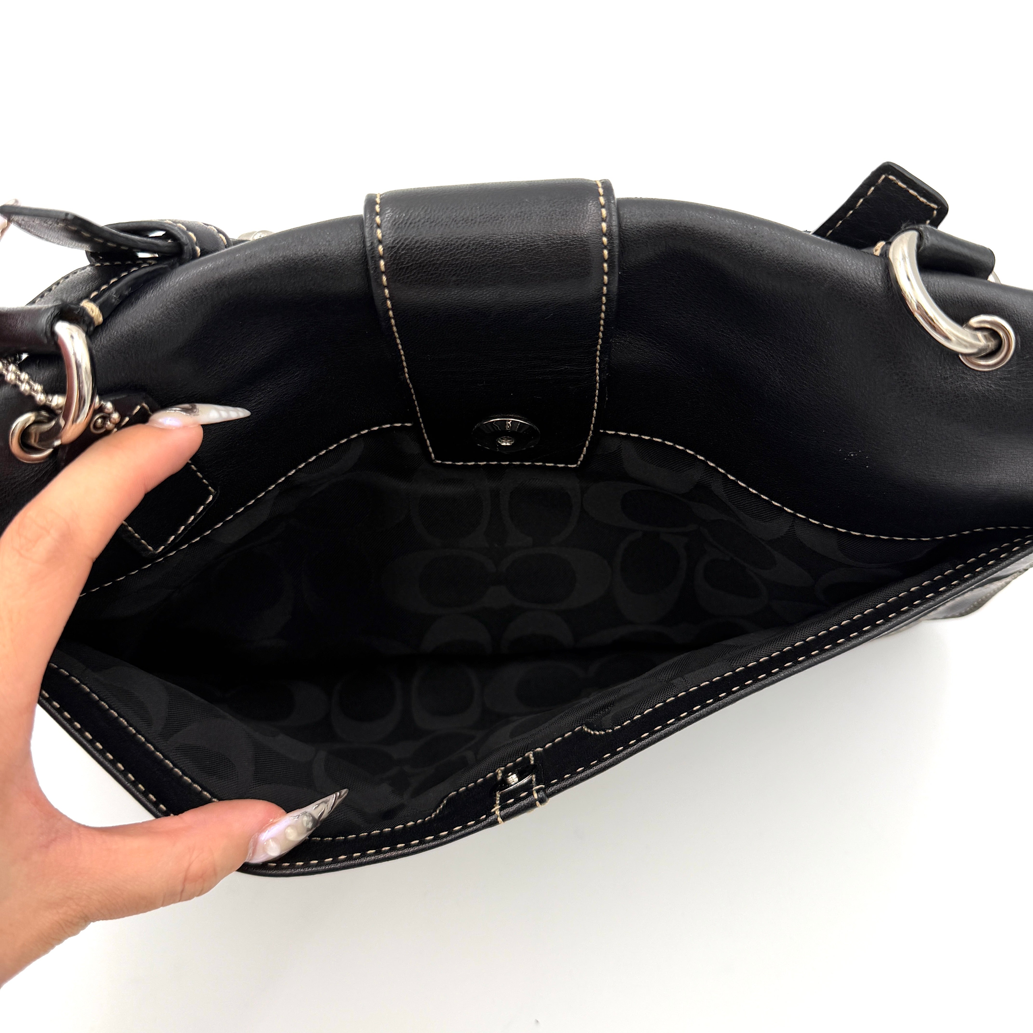 Coach Y2K Soho Buckle Shoulder Bag in smooth black leather with contrast stitching and a bold silver horseshoe buckle.