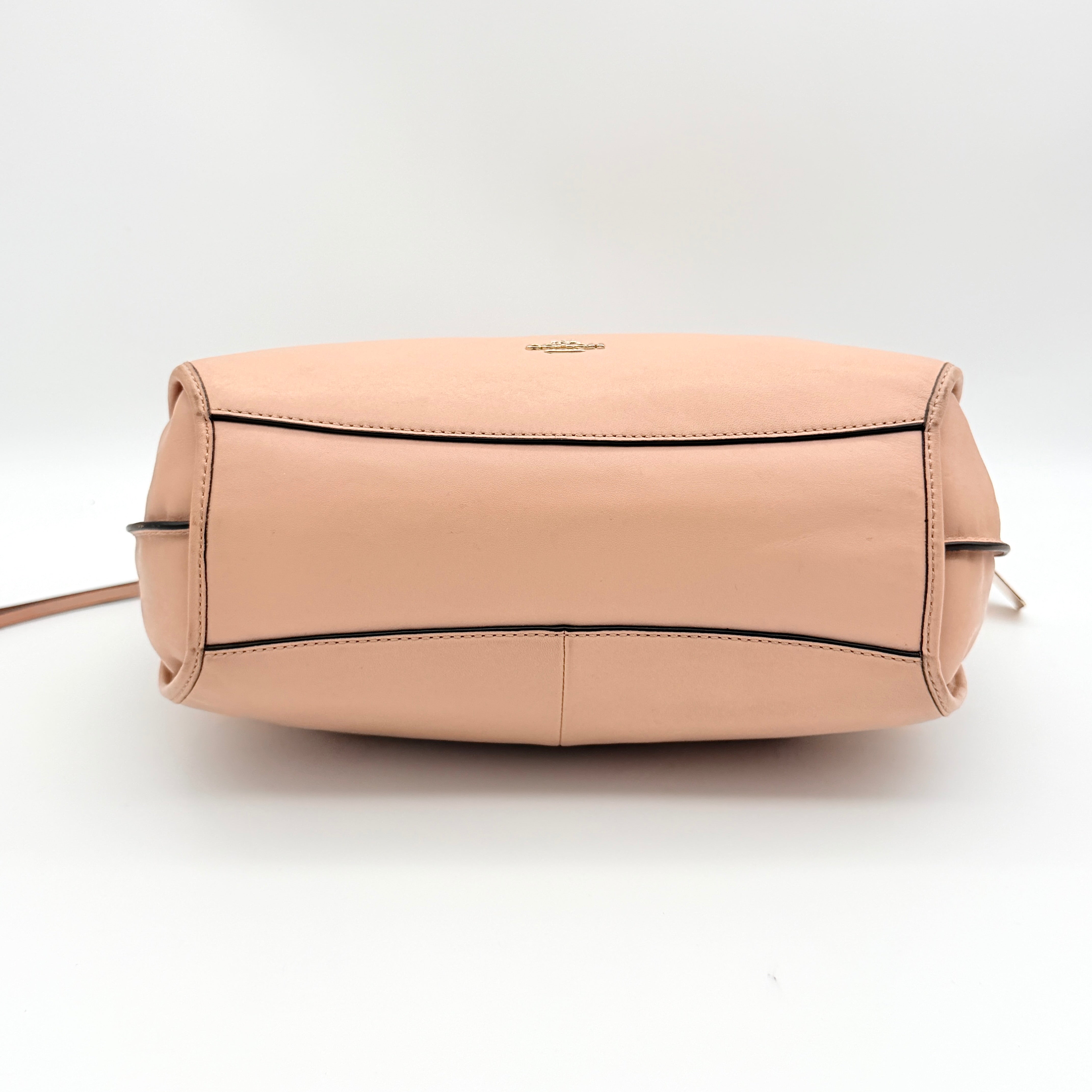 Coach Madison Smythe satchel in blush pink leather with gold-tone hardware and detachable strap, displayed against a white background.