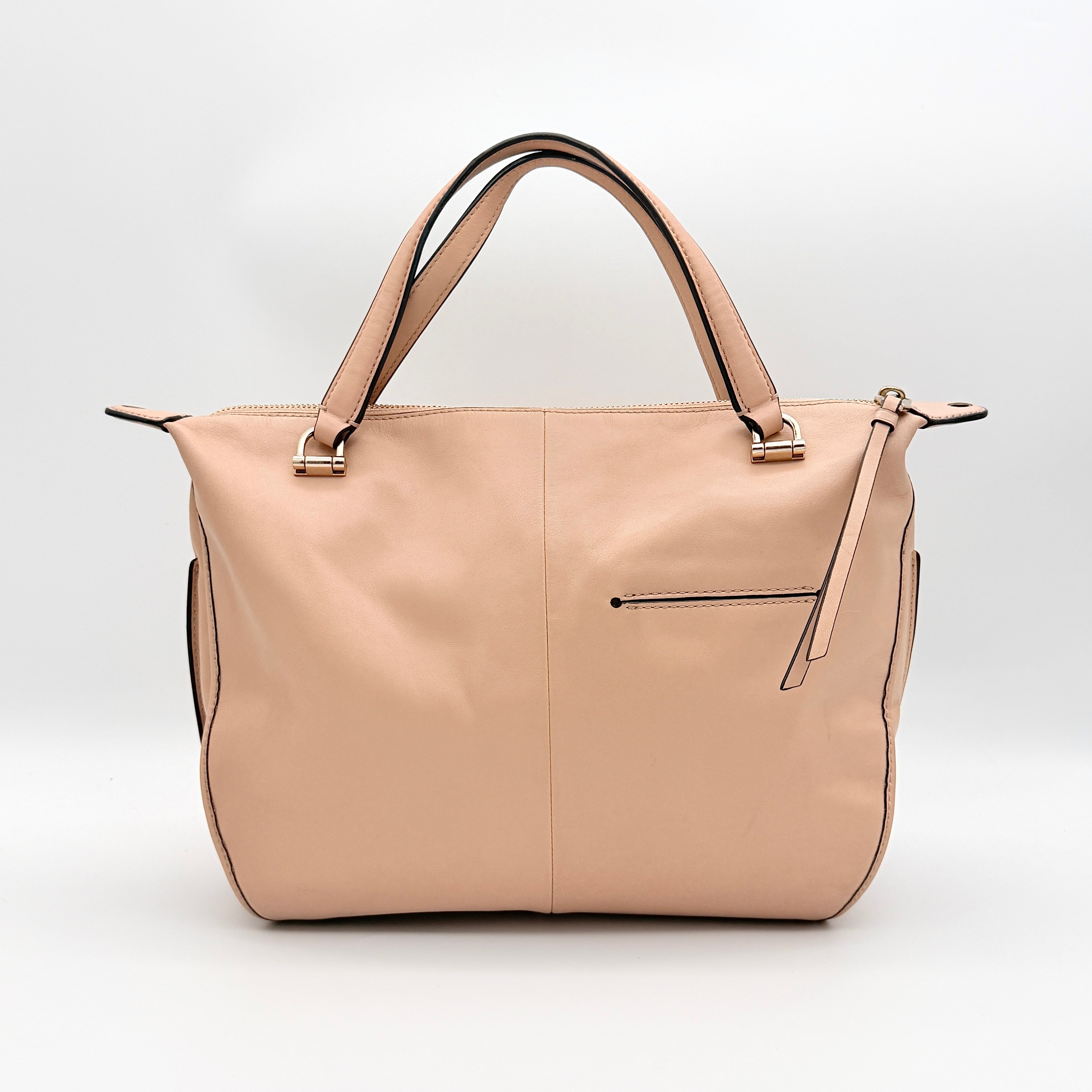 Coach Madison Smythe satchel in blush pink leather with gold-tone hardware and detachable strap, displayed against a white background.