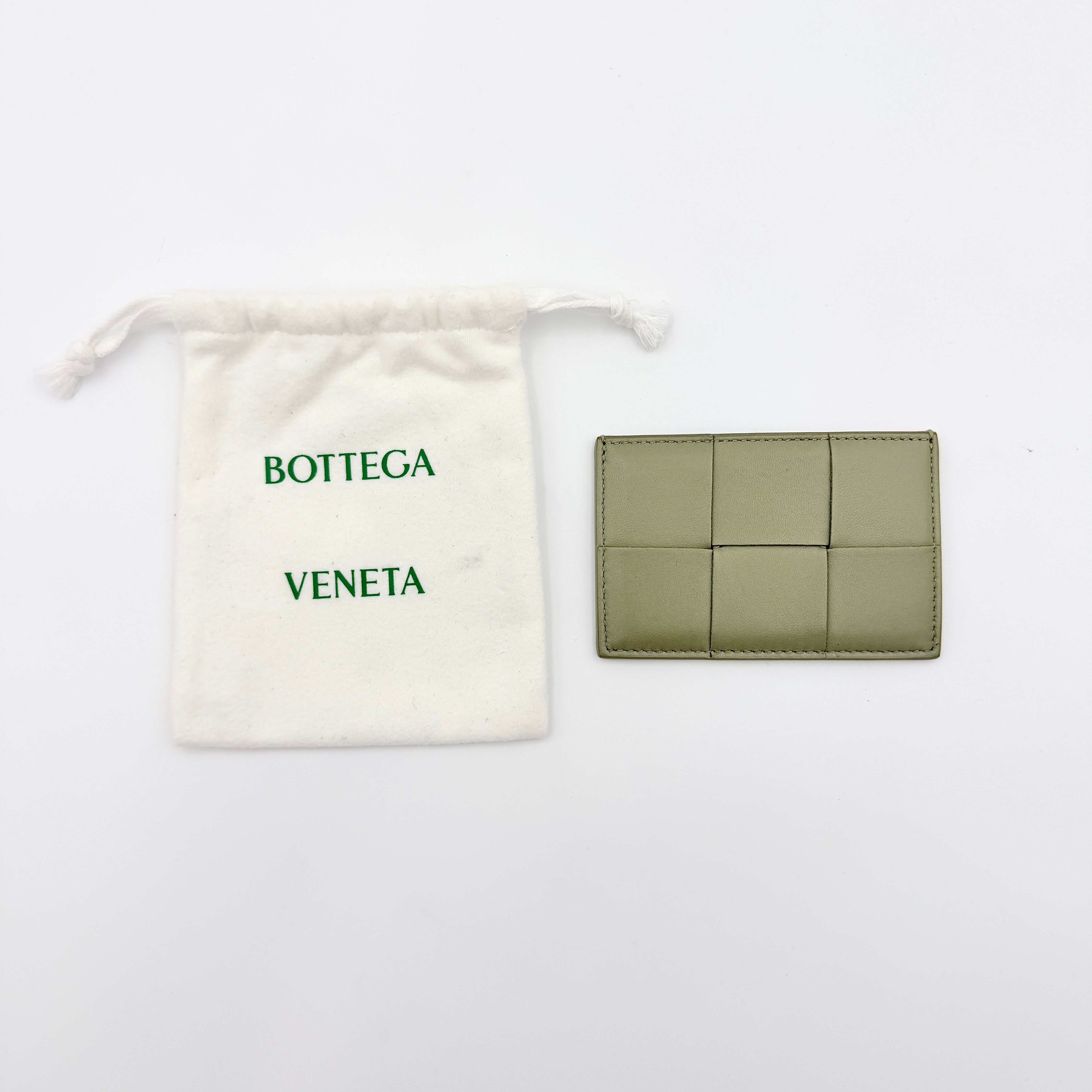 Bottega Veneta Cassette card holder in travertine green leather with signature padded Intrecciato weave, photographed against a white background.