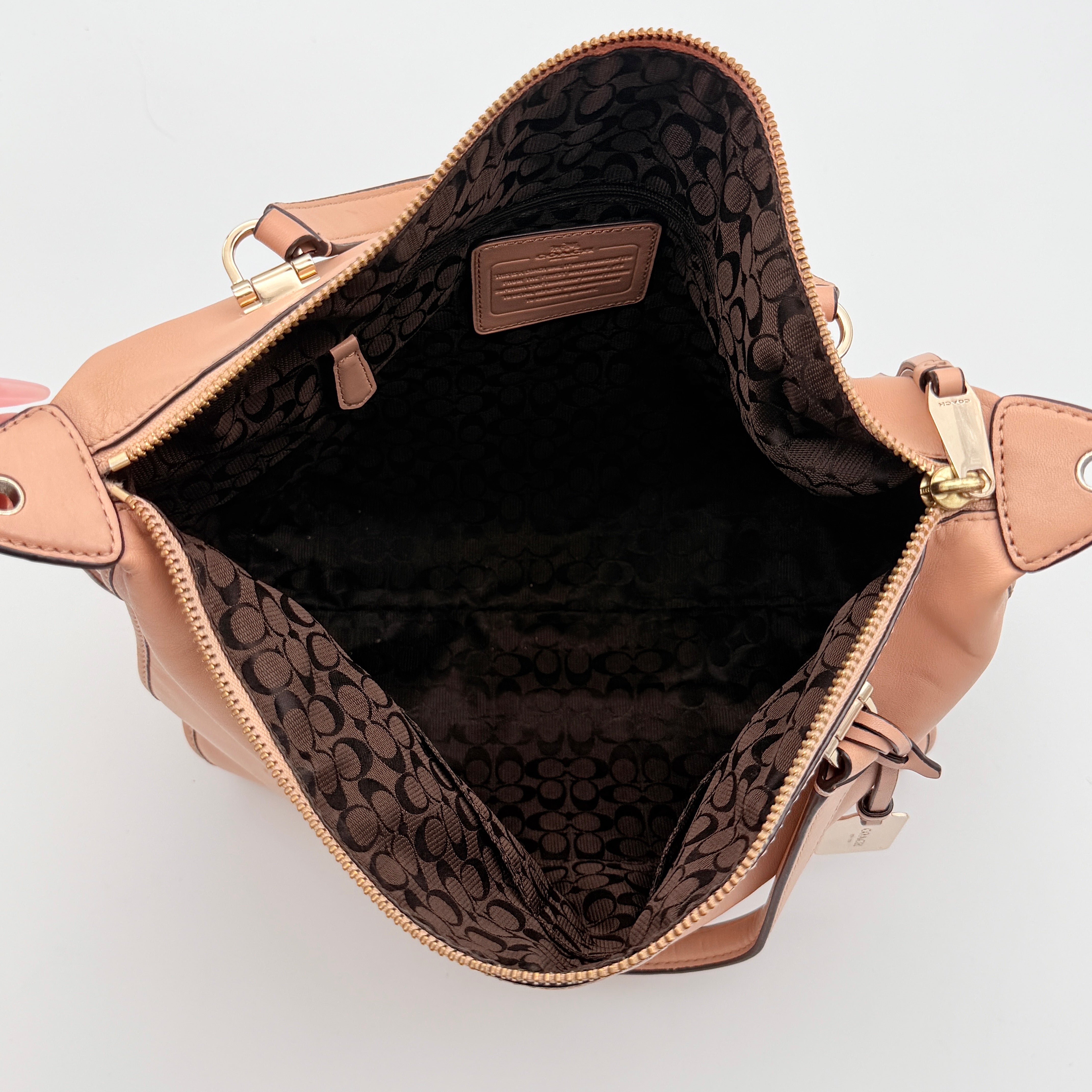 Coach Madison Smythe satchel in blush pink leather with gold-tone hardware and detachable strap, displayed against a white background.