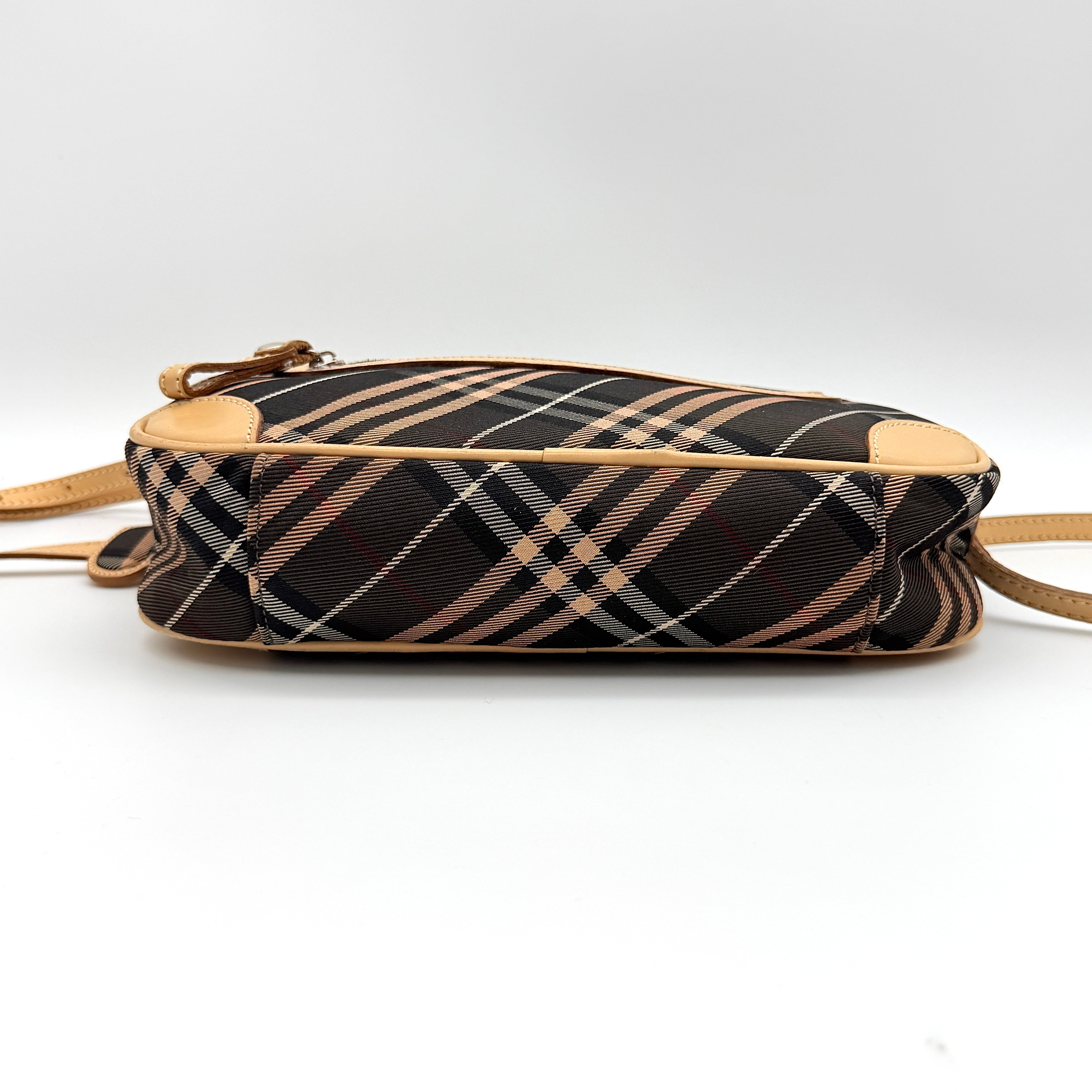 Burberry Blue Label Nova Check crossbody bag with tan leather trim and heart charm, styled on a white background.