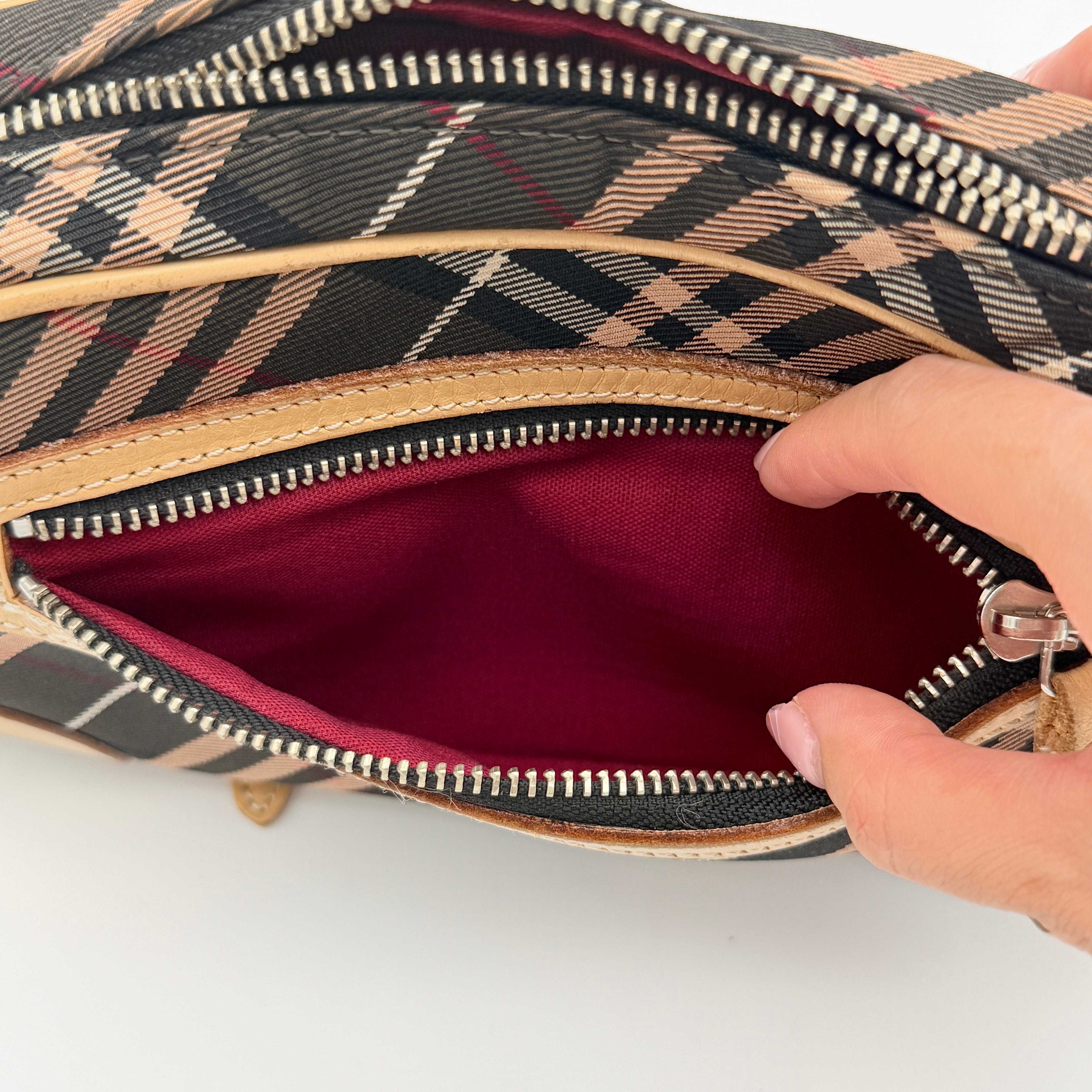 Burberry Blue Label Nova Check crossbody bag with tan leather trim and heart charm, styled on a white background.
