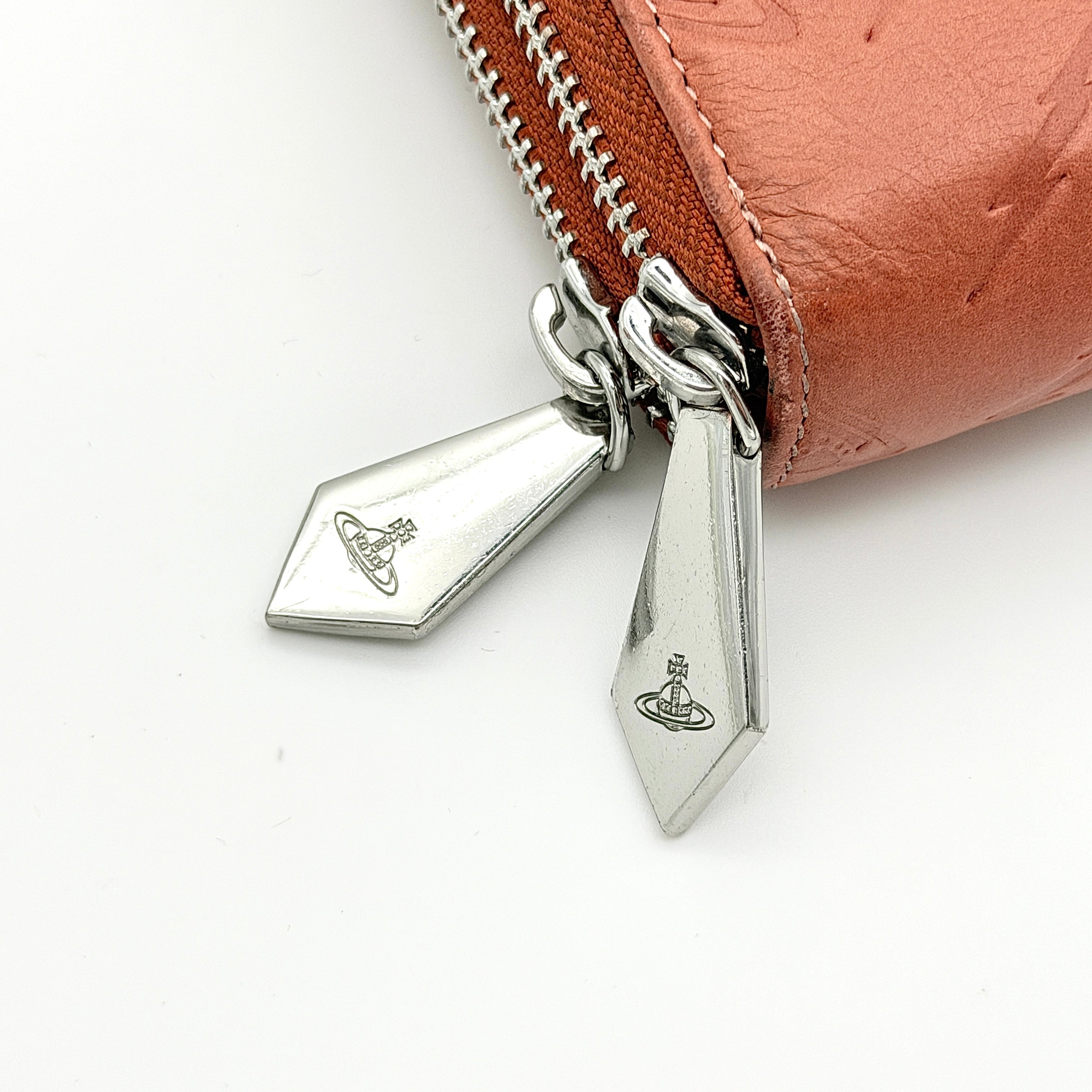 Vivienne Westwood 2Way Signature Orb Embossed Shoulder Wallet in coral pink leather with removable shoulder strap, shown with silver hardware.
