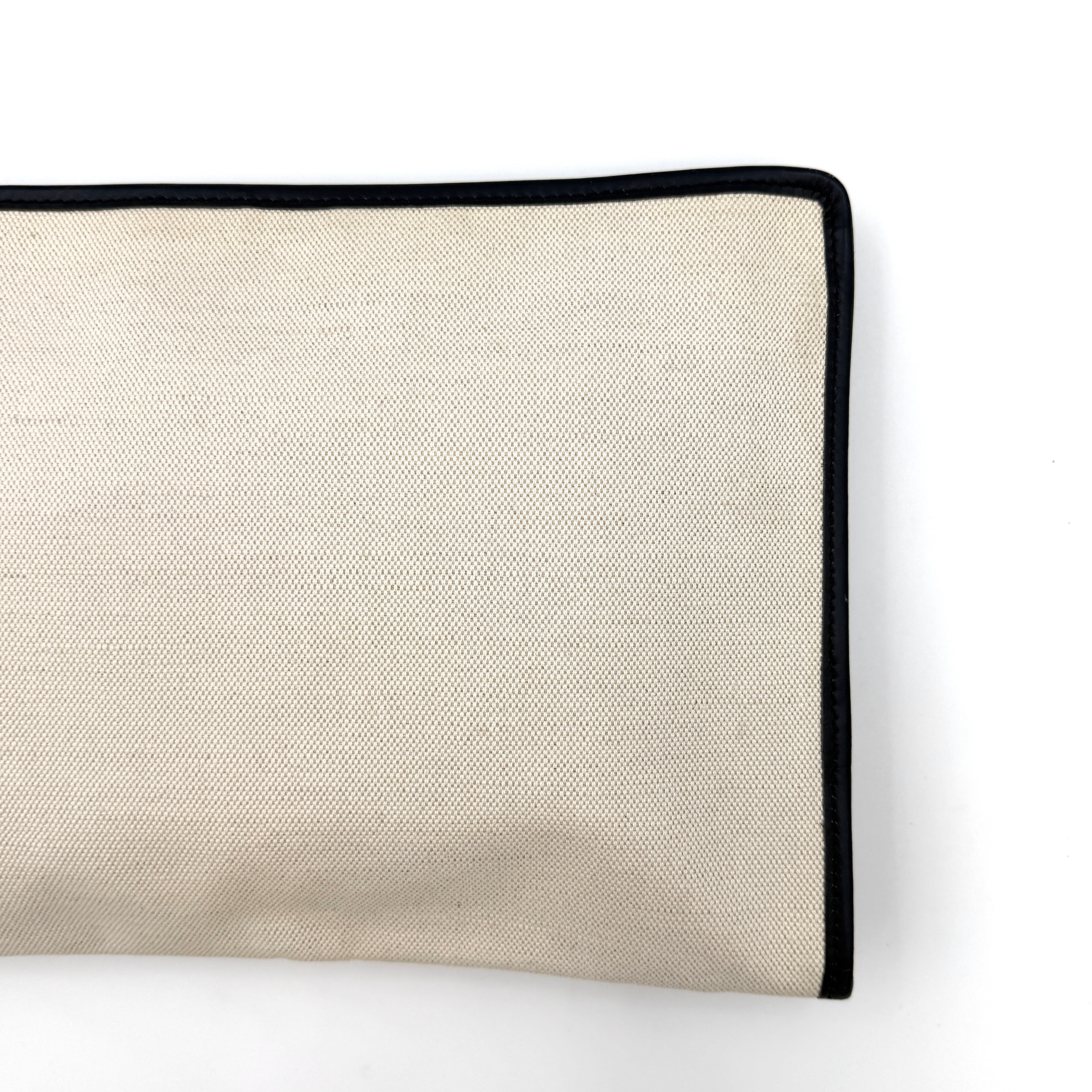 Balenciaga large ivory canvas clutch with black leather trim and logo, shown against a plain background.
