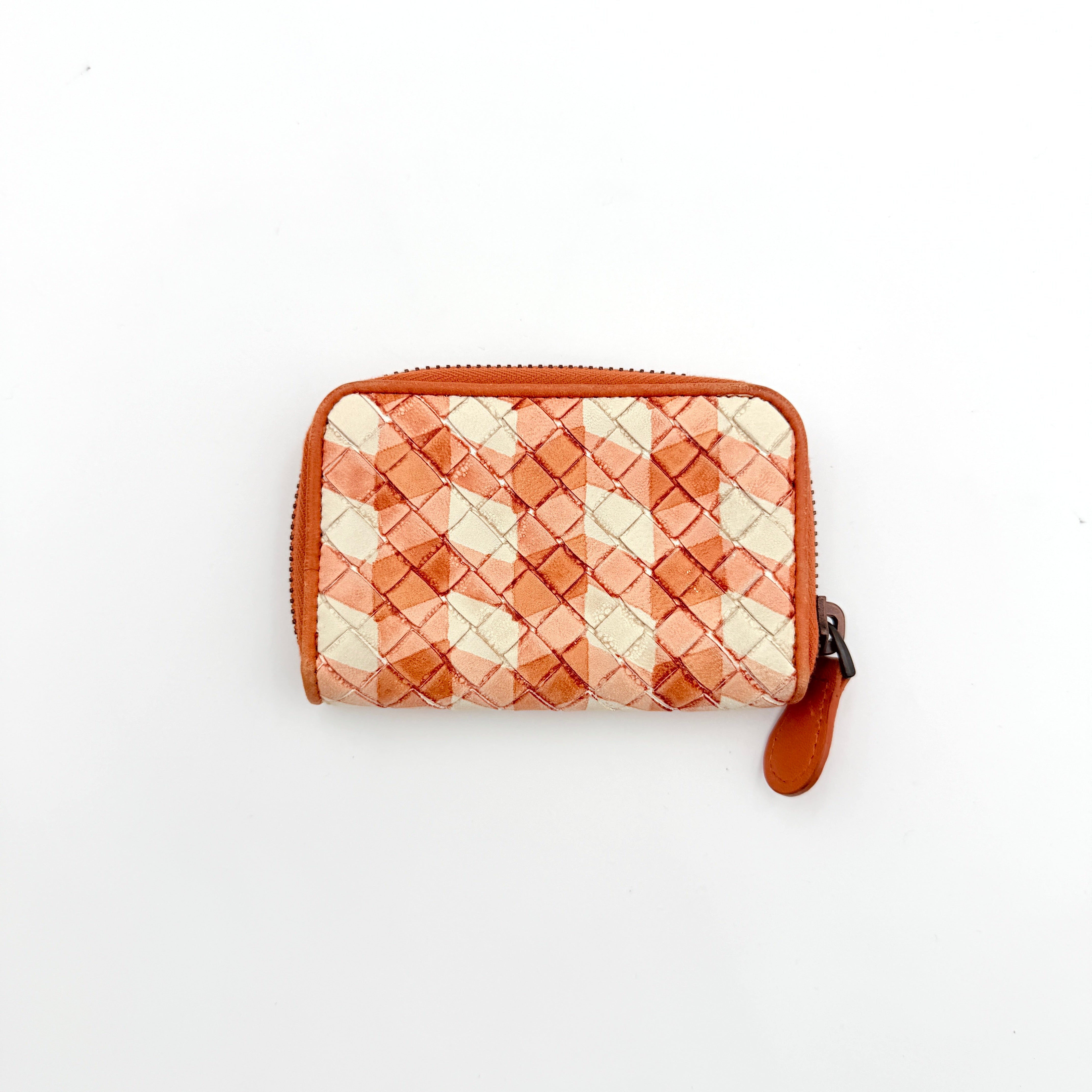 Front view of the Bottega Veneta Intrecciato zip around wallet in orange and white woven leather.