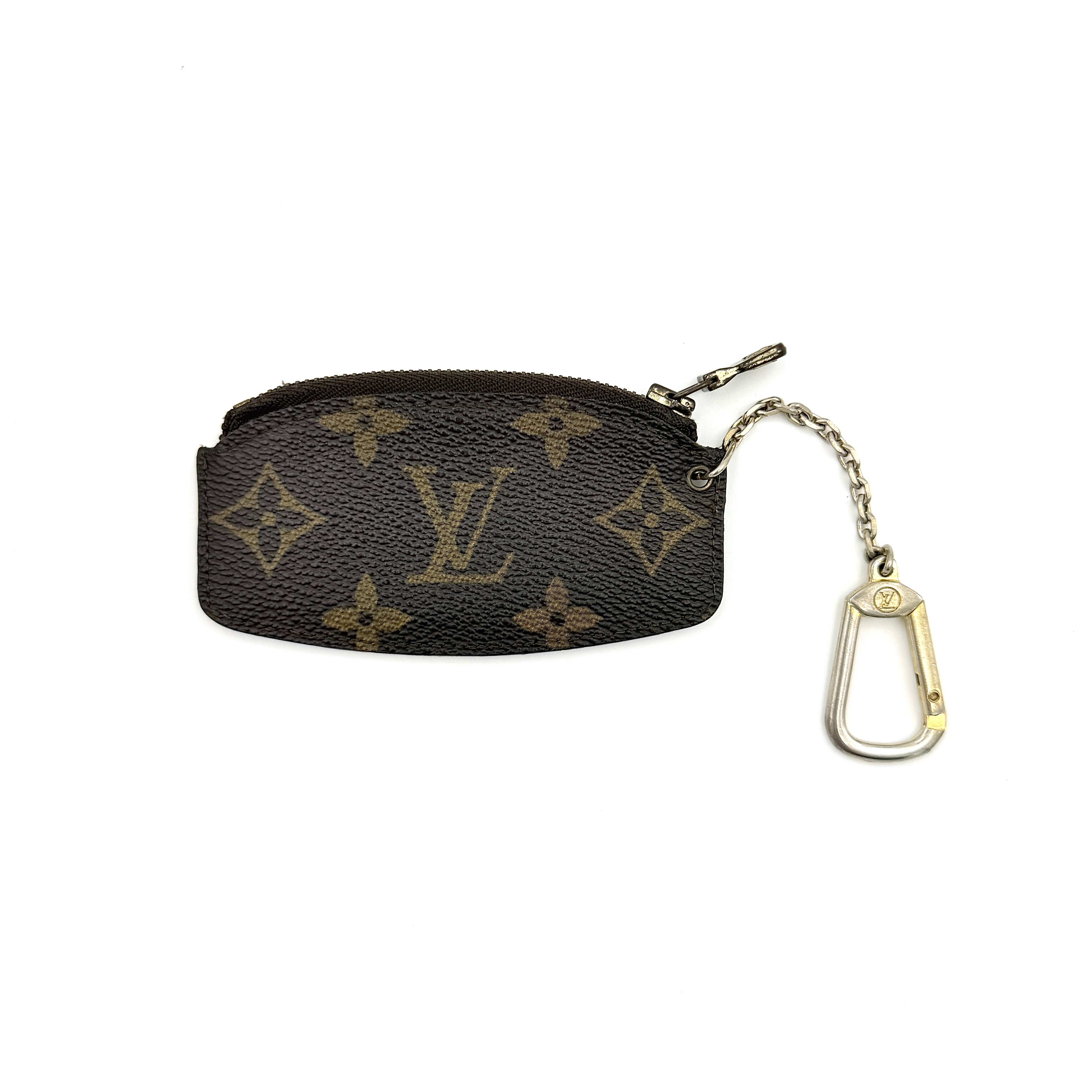 Louis Vuitton Monogram Cles coin case in brown canvas with gold-tone chain and clasp, photographed against a white background.
