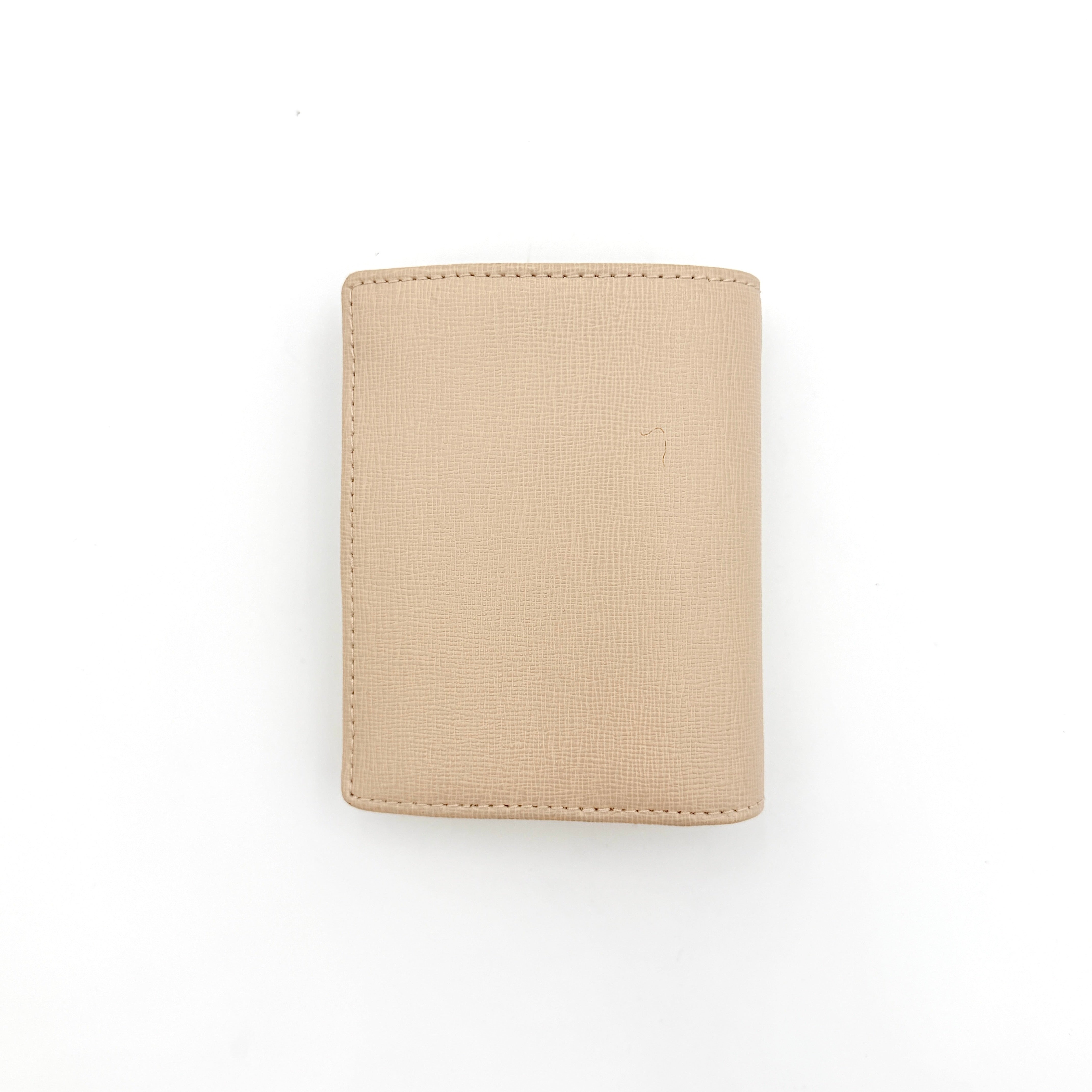 Furla Camelia S Compact Wallet in beige leather with gold-tone logo plaque, photographed against a clean white background.