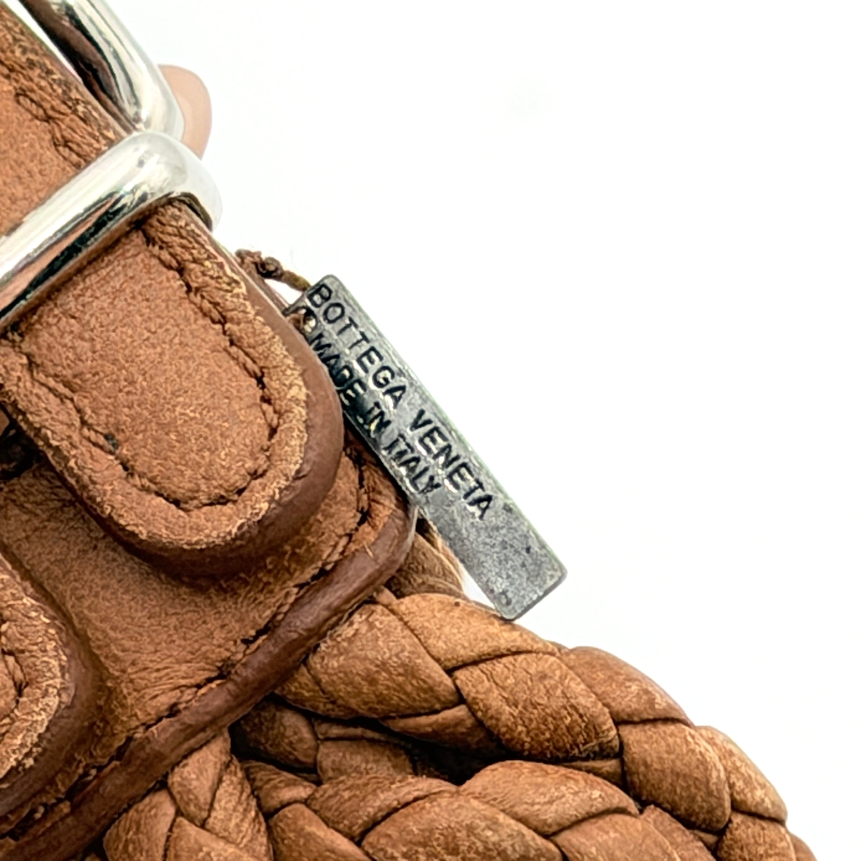 Bottega Veneta brown braided leather bracelet with silver-tone double buckle, displayed on a clean background.